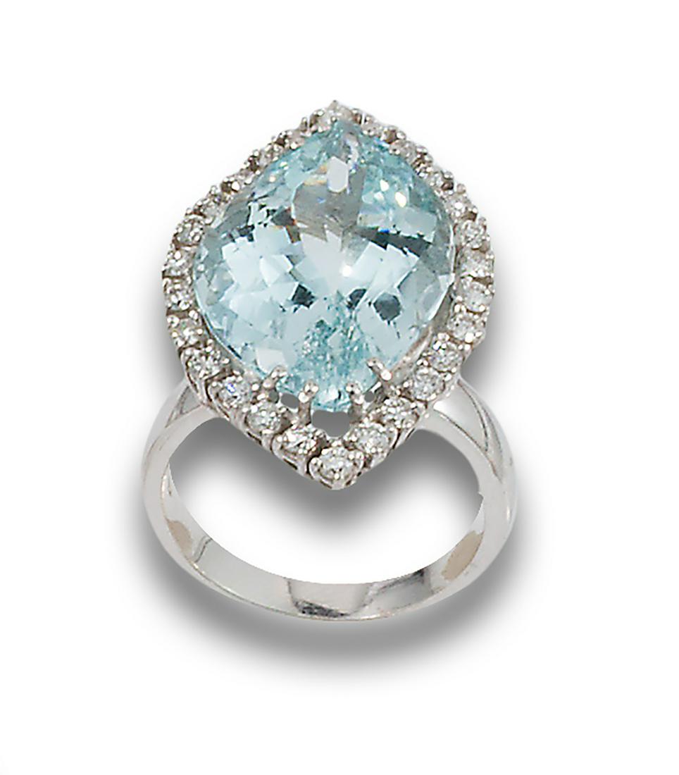 AQUAMARINE AND WHITE GOLD ROSETTE RING: 18 kt white gold rosette ring. formed by a central aquamarine, fantasy cut, bordered with diamonds, brilliant cut, set in claws.