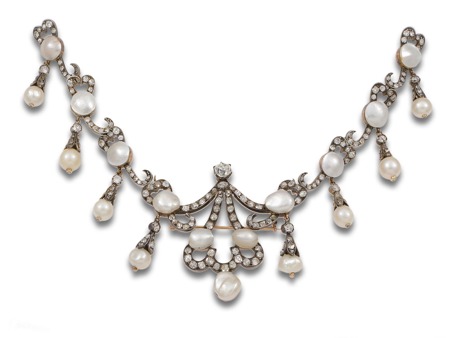 DEVANT-DE-CORSAGE, 19th century, IN GOLD, SILVER, PEARLS AND DIAMONDS: Devant-de-corsage, late 19th century, consisting of a brooch with detachable gold links and a silver front. Design of openwork scrolls with seven baroque pearls, possibly natural, calibrated between 1