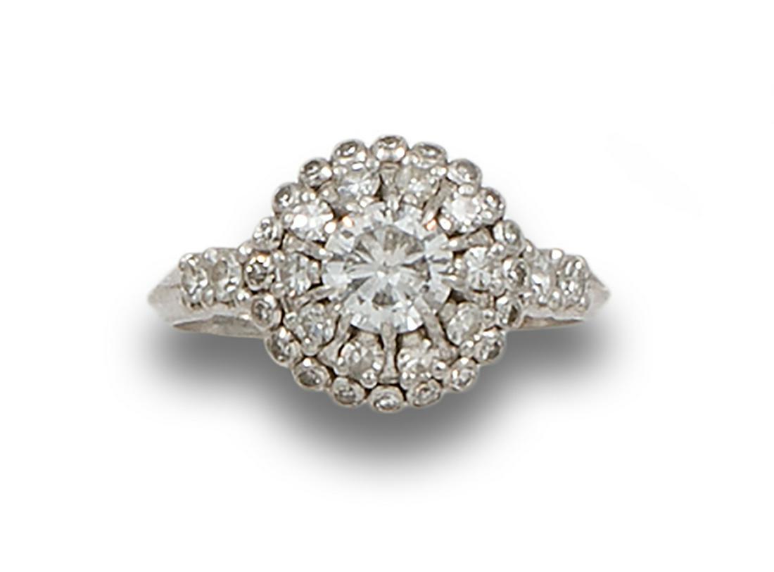 DIAMONDS AND PLATINUM ROSETTE RING: Platinum rosette ring. Formed by a diamond, central brilliant cut, estimated at 0.75 ct., Estimated color GH, Estimated purity VS, with double border of diamonds, simple cut. Claw setting.