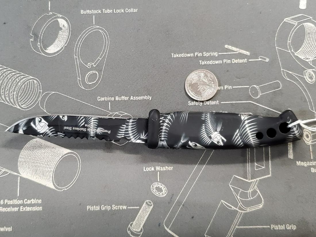PREMIUM EVOLUTION FISHBONE KNIFE: PATTERNS OF FISH SKELETONS ON BLADE AND HANDLE. BLADE HAS RIDGES ON BACK, LITTLE SHARP. SEE PICS. COIN FOR SIZE REFERENCE ONLY, NOT INCLUDED