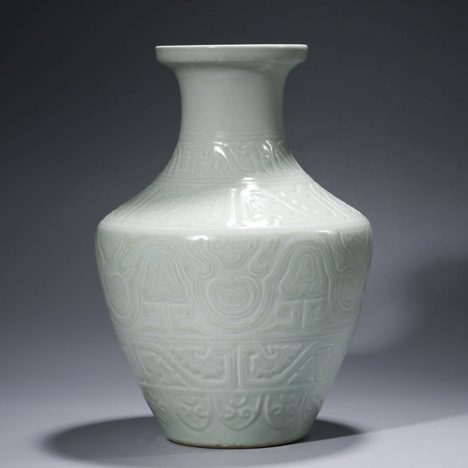 A CHINESE CELADON-GLAZED PORCELAIN VASE, QIANLONG MARK: Dimensions: Diam.26.9cm, Height: 38.1cm, Decorated to the body with a taotie mask,wide band of scrolling patterns at the bottom, a further scrolling lotus band to the shoulder and a band of stiff leav
