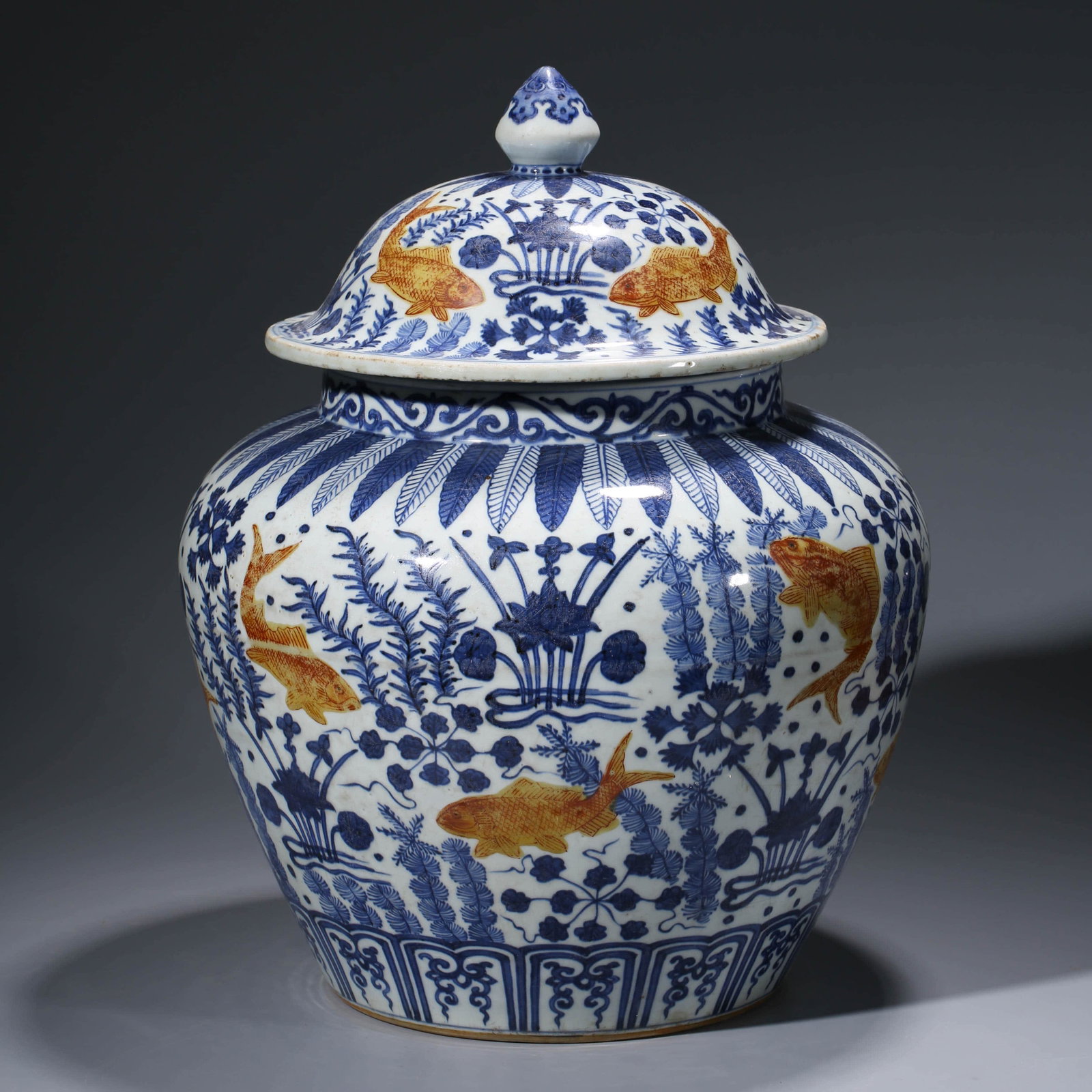 A CHINESE IRON-RED-GLAZED PORCELAIN JAR & COVER WITH: Dimensions: Diam.35.4cm, Height: 44cm, Of sloping shoulder and a cover with a knob on, the jar depics red carps swimming in sea around sea grass.