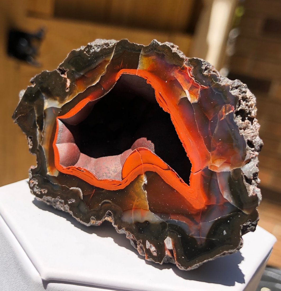 Red Fox Agate Geode Half: "Red Fox" Agate geode half. These rare hematite included geodes are very hard to attain. Most specimens are UV reactive under various lighting. Argentina. 114.2 Grams. Approximately 80mm X 50mm X 35mm