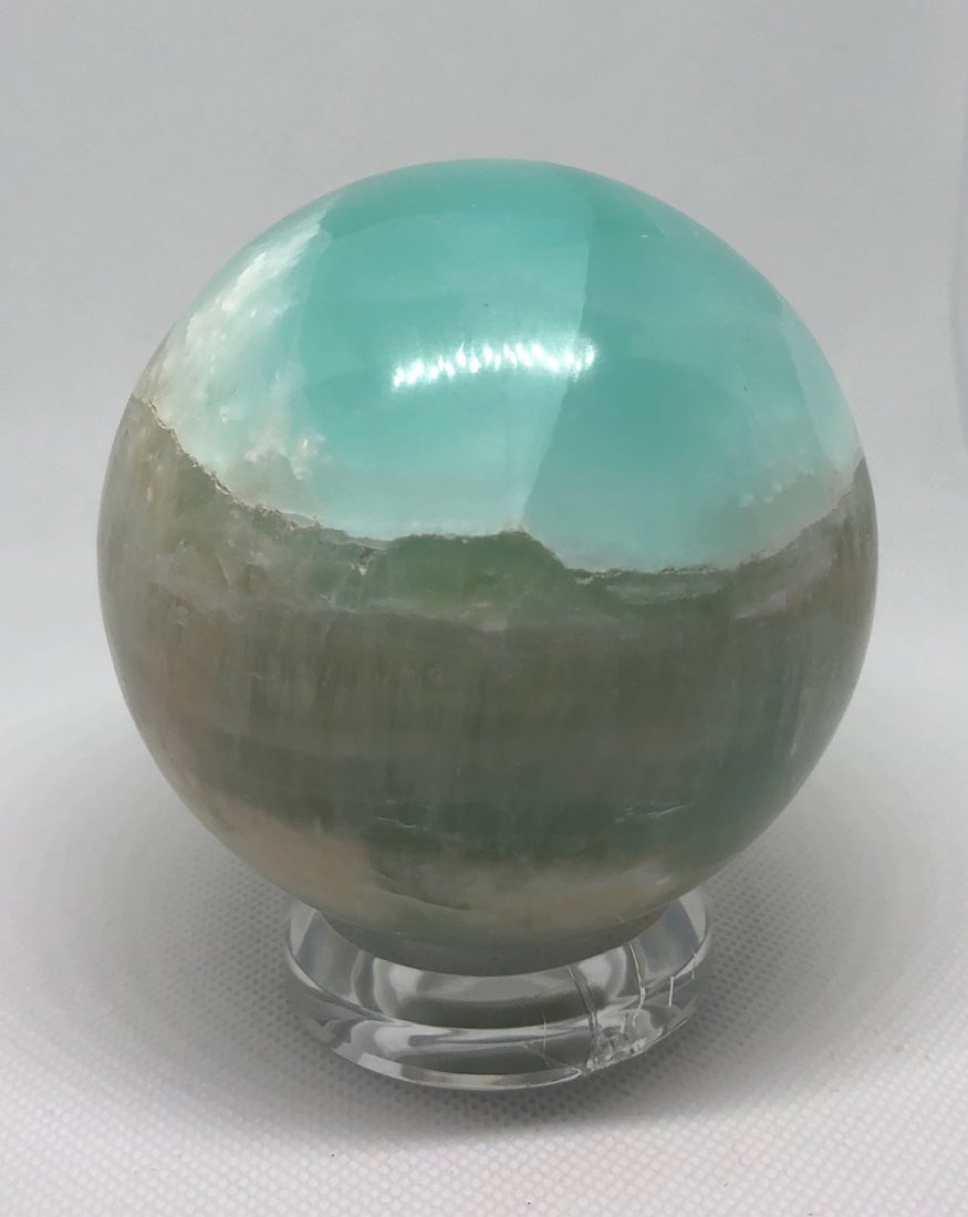 Blue "Caribbean" Calcite Sphere: Beautiful blue "caribbean" calcite sphere. These are absolutely amazing. They do have natural vugs. Approx 3.5" diameter 870 grams. AS ALWAYS WE OFFER IN-HOUSE SHIPPING VIA USPS FLAT RATE SHIPPING, NO