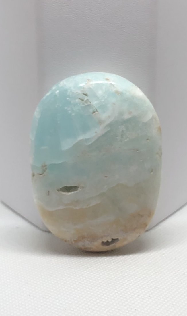 Blue "Caribbean" Calcite Palm Stone: Blue "caribbean" calcite palm stone with natural vugs. Approx 2.5" x 1.75". AS ALWAYS WE OFFER IN-HOUSE SHIPPING VIA USPS FLAT RATE SHIPPING, NO EXTRAVAGANT SHIPPING FEES!