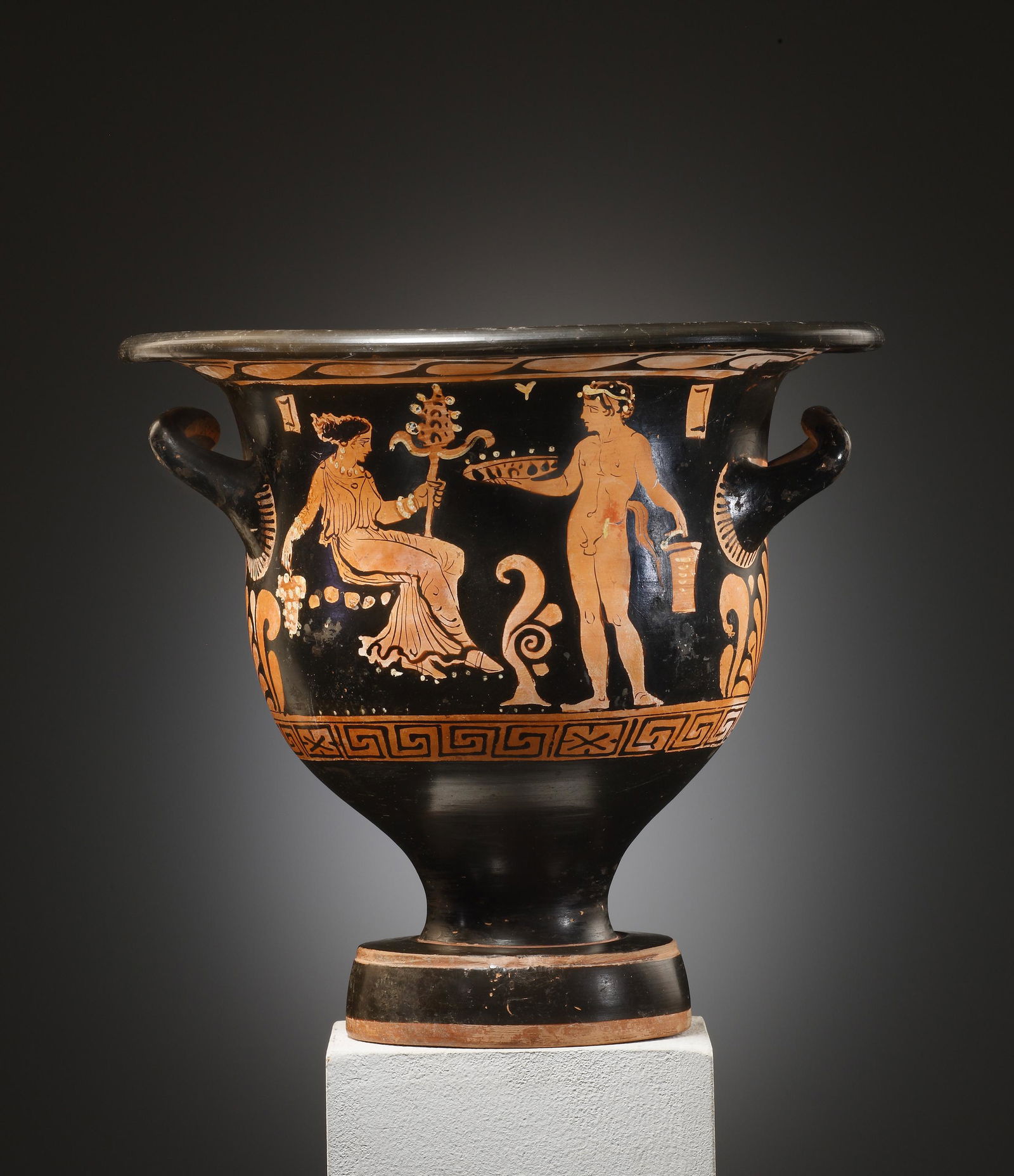 An Apulian Red-Figure Bell-krater with Dionysian scene;: Apulian mid-4th cent. B.C. Clay. H. 28.2 cm. A thick-walled bell-krater on a robust foot. On the obverse, a seated maenad to the left holding a beribboned thyrsos. A languid, youthful satyr stands bef