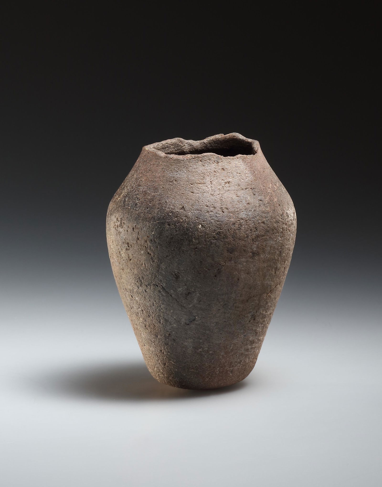 Jar: Egyptian, possibly Late Prehistoric end of 4th mill. B.C..Grey-brownish quartzite (?). H. 12.5 cmTall shouldered jar. Neck and rim missing.Collection Carl Leonhard Burckhardt (1902-1965).