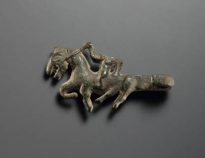 Belt Ornament with a Rider on a Galloping Horse: Thracian 3rd cent. B.C. - 2nd cent. A.D..Bronze. L. 5.1 cmIn the extension of the strongly incurved hook, a muscular horseman, presented frontally, rides on his galloping horse. With its large head