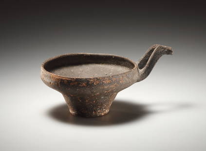 A Small One-handled Cup (Base Ring Ware): Eastern Mediterranean, Late Bronze Age 1475-1225 B.C..Clay. Dm. 10.5 cmWide body with angled shoulder and slightly drawn-in rim with S-shaped stirrup handle attached to it. Conical foot moulded out