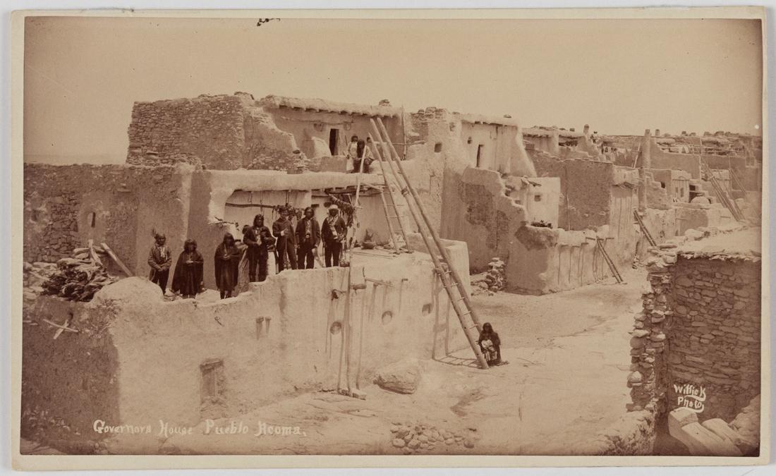 Wonderful rare BEN WITTICK ACOMA, NEW MEXICO 1890: BEN WITTICK Governors House, Pueblo Acoma NM 1890 c., Albumen 5x8" Boudoir Card ASG# BW2/1377. The Governor and other Pueblo officials pose on the first floor roof of the line of connected houses. A w