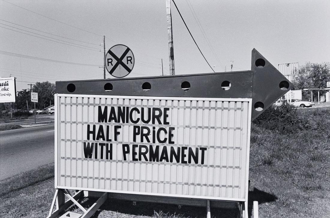 LEE FRIEDLANDER Manicure Half Price Alabama 1983: LEE FRIEDLANDER 644-9: Alabama [Manicure Half Price with Permanent], 1983, 10.5x16.6" on 14x17" paper. Signed, titled and dated verso copyright stamp no date. ASG# LF/1289 An over-size print of one o