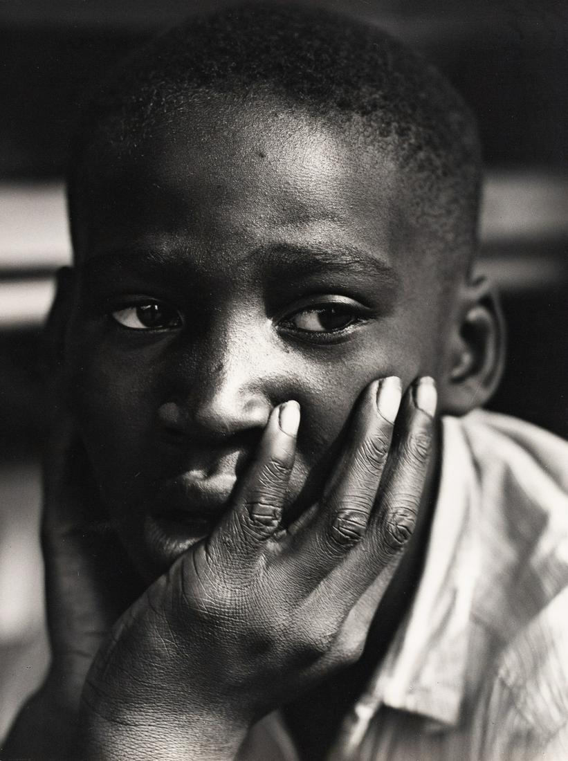ANDRE DE DIENES Child Portrait 1950: ANDRE DE DIENES. Untitled (boy with hands on cheeks), c. 1950. 13x9.7" gelatin silver print. Printed c. 1950s. Permission stamp in green ink on print verso; stamped in green ink: Photo / Andre de Dien