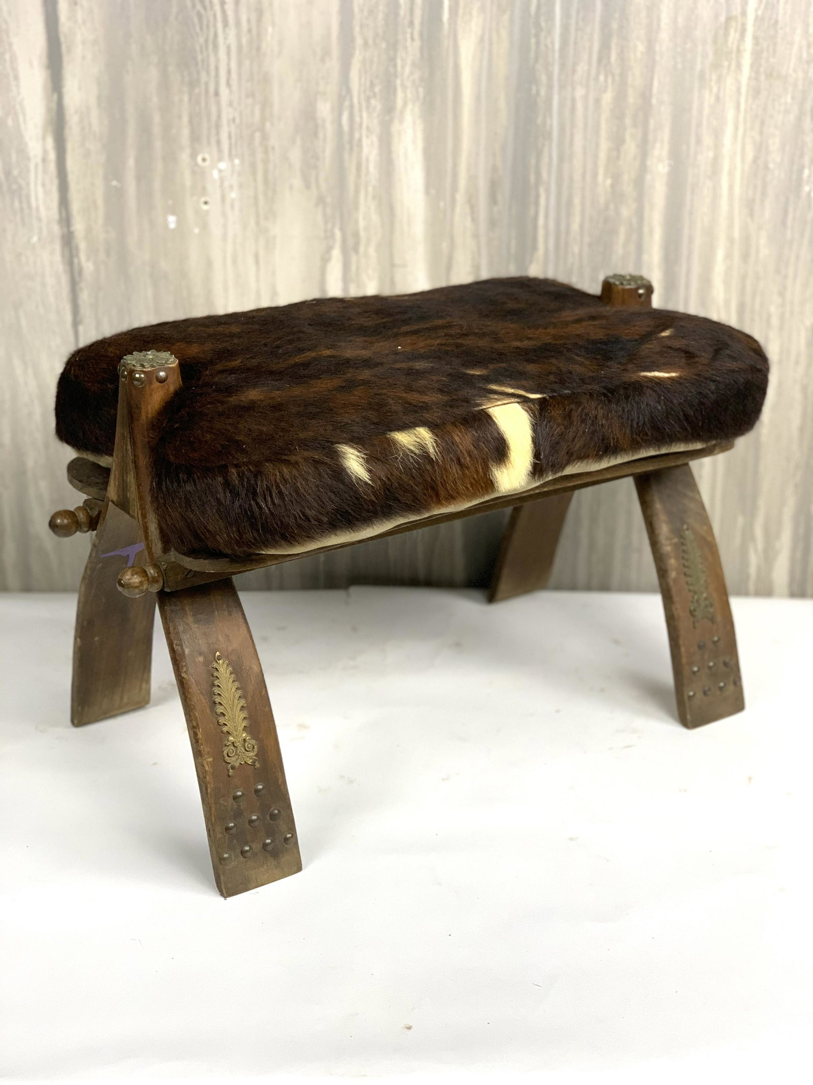 European Hide Footstool: Beautiful vintage hide fireplace footstool with brass accents from France. Oak frame. Circa 1920