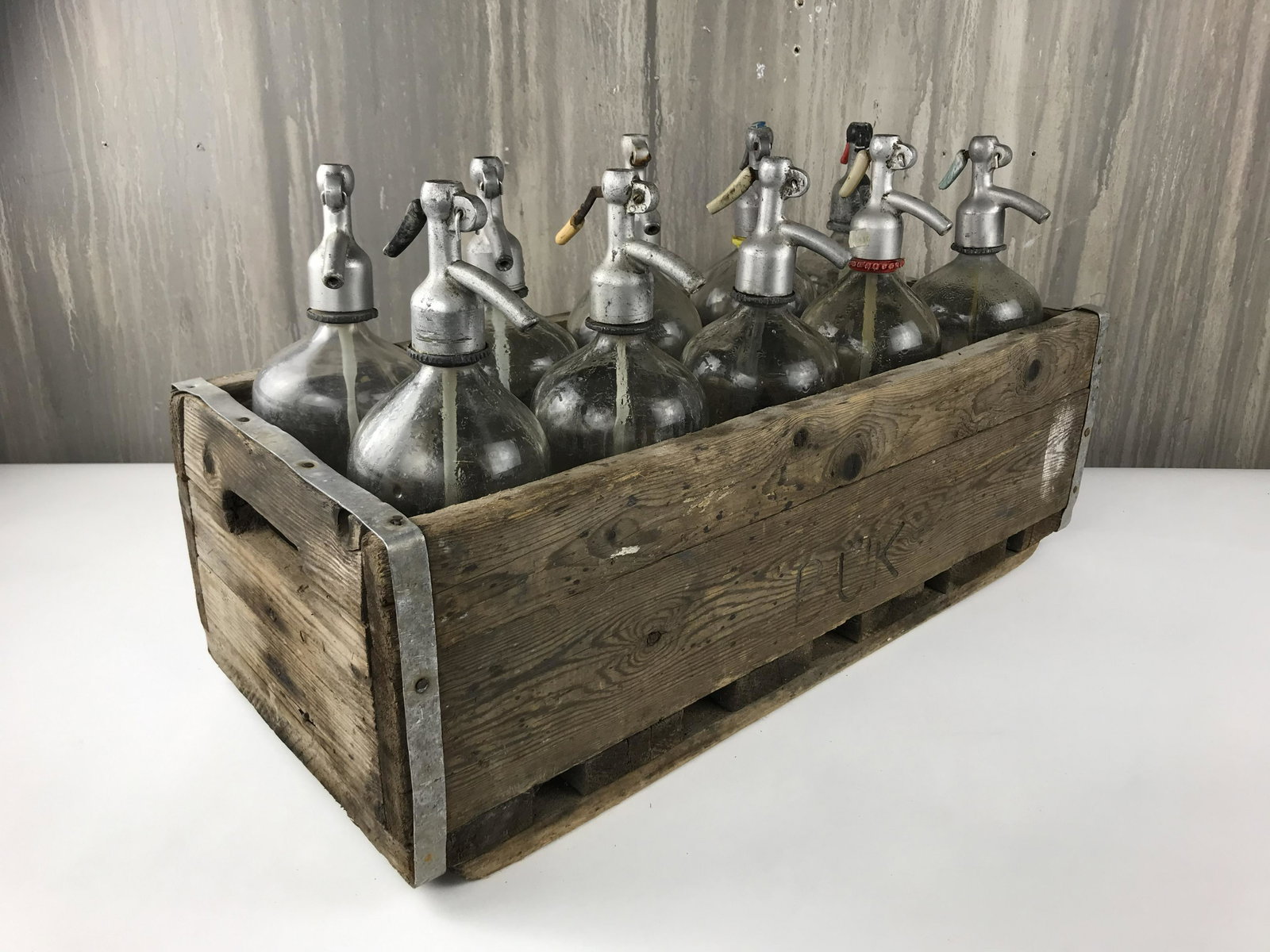 Lot of 10 Seltzer Bottles and Crate: Lot of 10 Vintage seltzer bottles and crate. Display as is or separate the bottles throughout a bar or bookshelf. Repurpose the wood crate as a planter, storage crate, anything! Circa 1960, Germany
