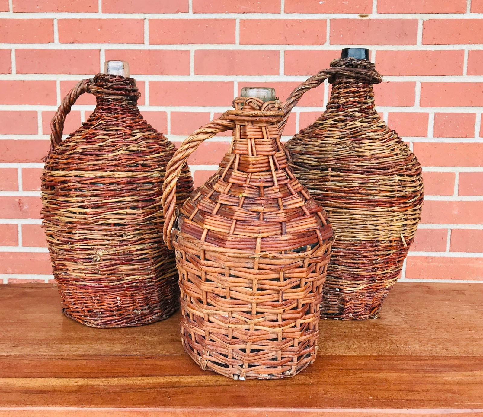 Vintage Style Wicker Demijohn Bottle, set of 3, from Spain.: Vintage glass demijohn wine bottle wrapped in a natural woven straw finish, from Spain. Left (green glass) 17" x 9" diameter, Middle (clear glass) 13" x 8"diameter, Right (clear glass) 16" x 10" diame