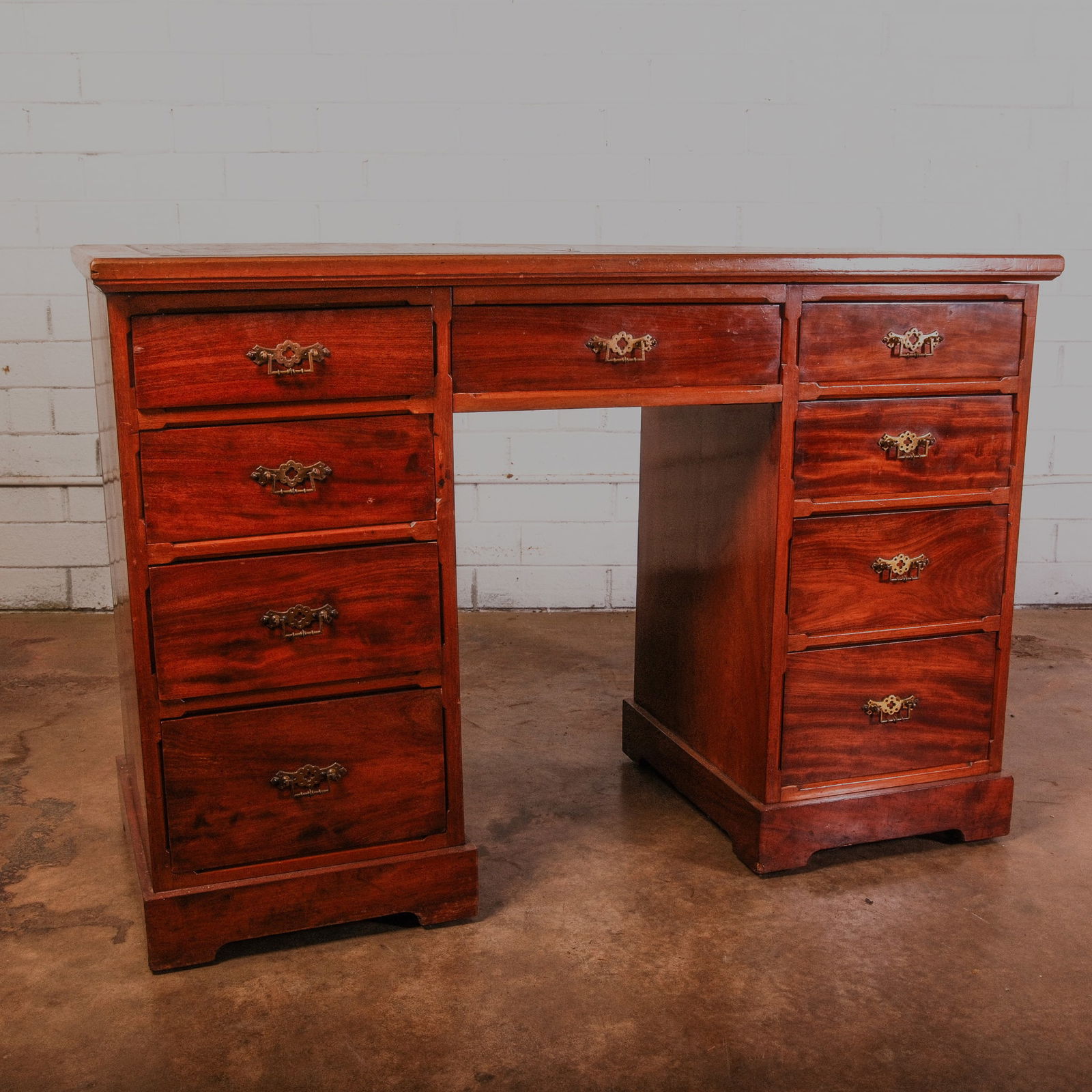 Victorian Mahogany Pedestal Desk: Victorian Executive Desk with Pedestal base. Includes the original gold accented black kid leather blotter. The 4 side by side pull out drawers and center drawer all have original brass hardware.