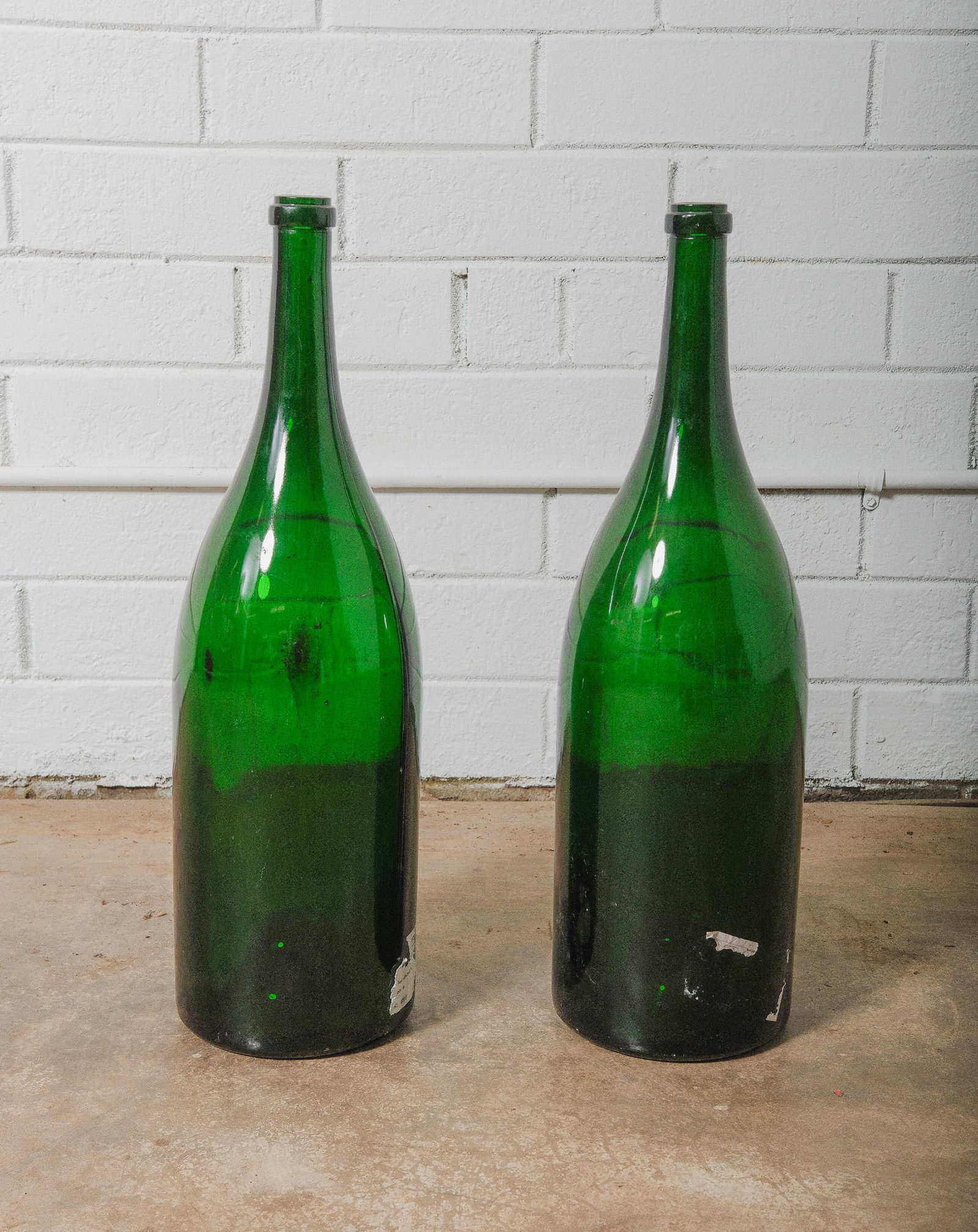 Pair of Vintage Green Glass Belgium Beer Bottles 6 liters: Pair of vintage Belgium beer bottles, crafted in classic deep green glass with graceful tapered necks and broad shoulders. Each bottle holds 6 liters, equivalent to 8 standard bottles, making them bot