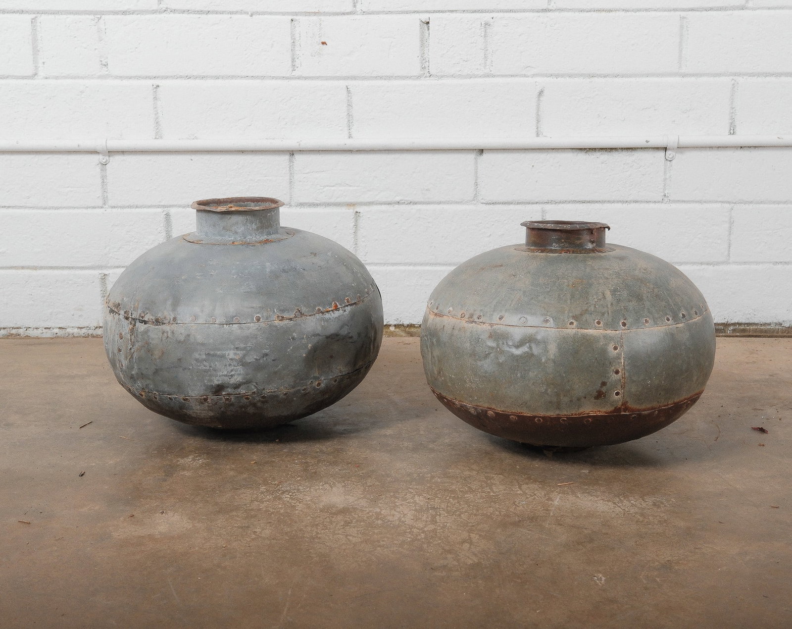 Primative Metal Nigiri Pots, one Pair: These traditional hand forged metal water or storage pots originate from India, specifically the Nagaland or Northern Eastern tribal regions, and were used to transport and store fresh water in remote