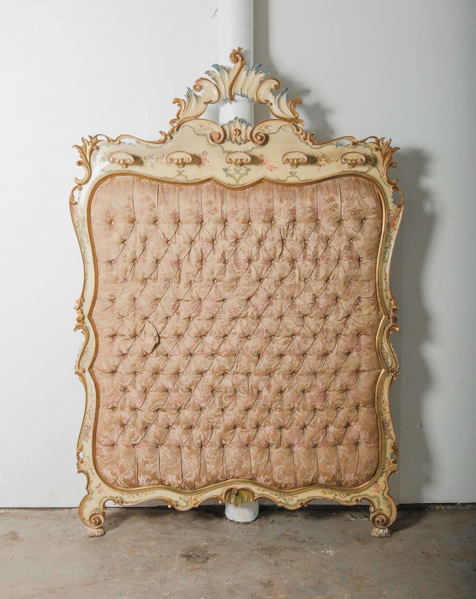 Italian Rococo Hand Carved Headboard with Tufted Damask Upholstery: Dramatic, ornate, and undeniably regal, this antique Italian headboard is a true showpiece. Featuring a heavily carved wood frame with an arched crest, scroll flourishes, and floral embellishments, th