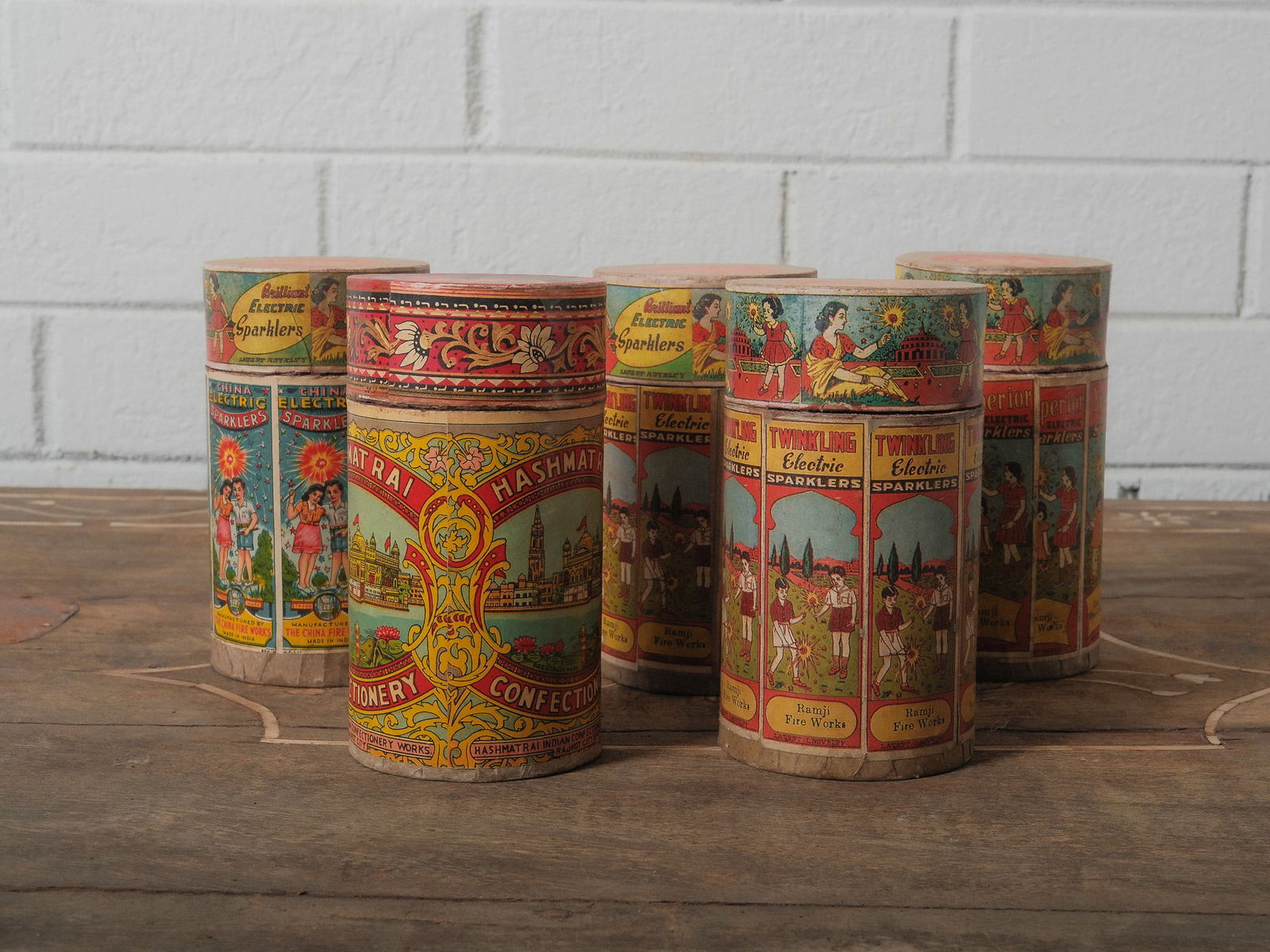 Set of 5 Vintage Firework Canisters: Set of vintage firework canisters with brightly colored lithographed labels, including China Electric Sparklers, Twinkling Electric Sparklers, and Hashmat Rai Confectionery. Excellent graphic appeal f