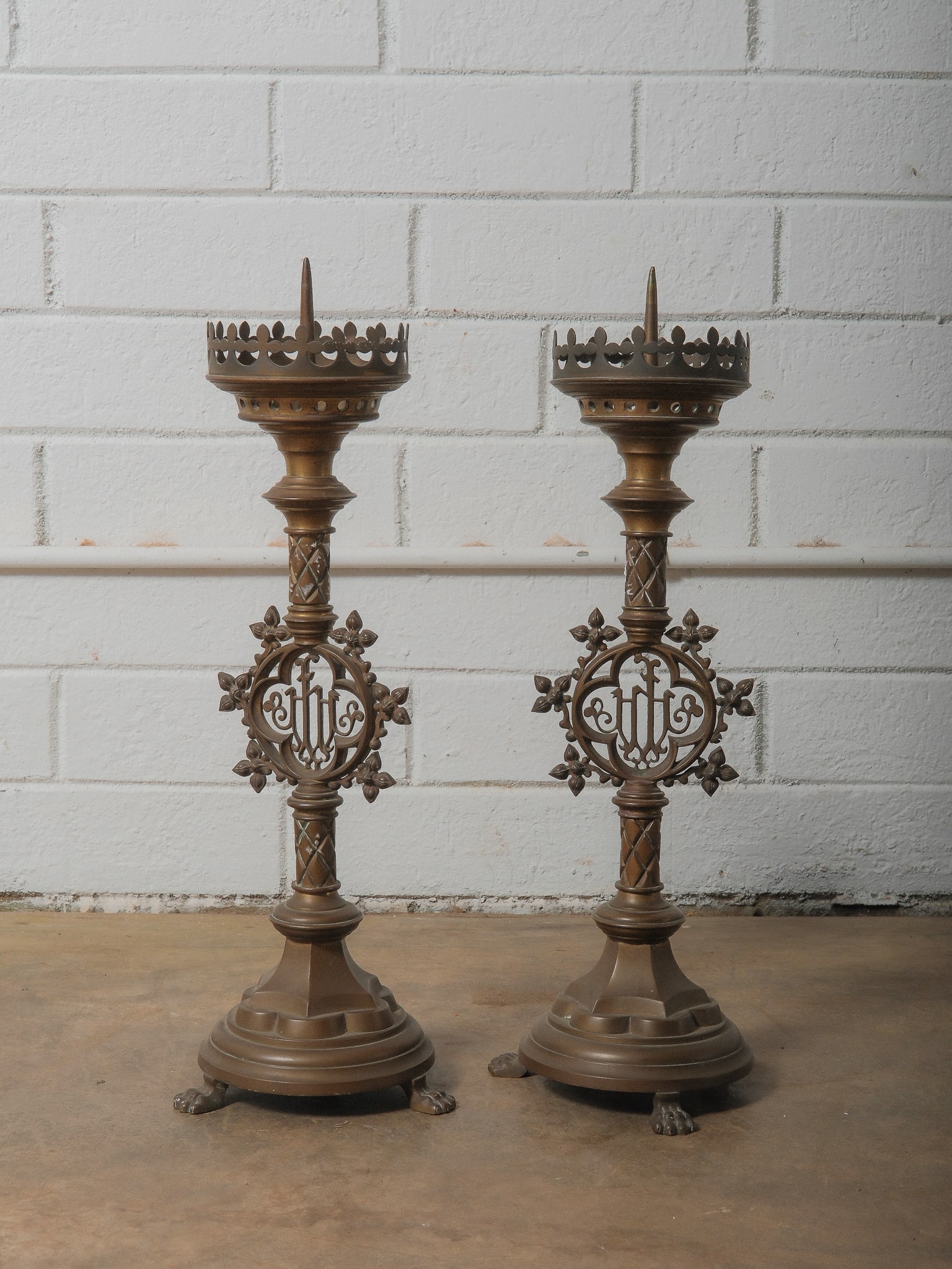 Pair of Cast Brass Altar Candlesticks: Magnificent pair of cast brass ecclesiastical candlesticks featuring Gothic motifs, crowned tops, paw feet, and a central medallion. Substantial weight and presenceperfect statement religious or decor