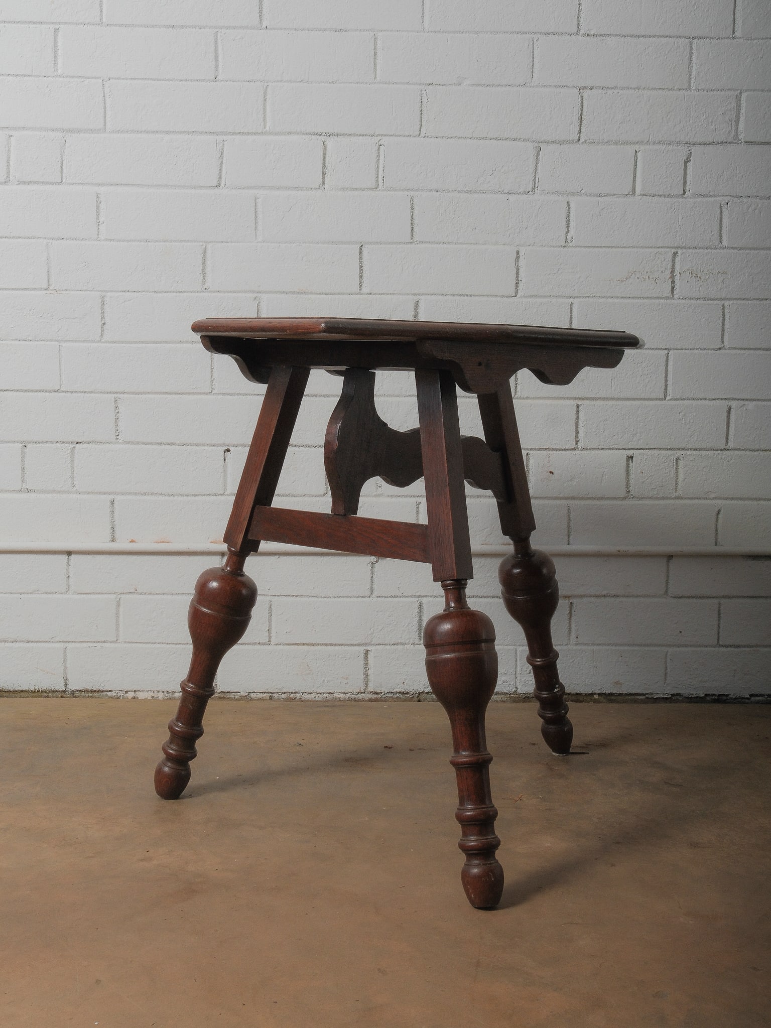 Oak Polygon Gateleg Table: A charming three-legged table with a polygonal top, supported by beautifully turned legs and a shaped apron. It's compact size makes it ideal as an accent table or plant stand. Measures 29"h x 28"w x