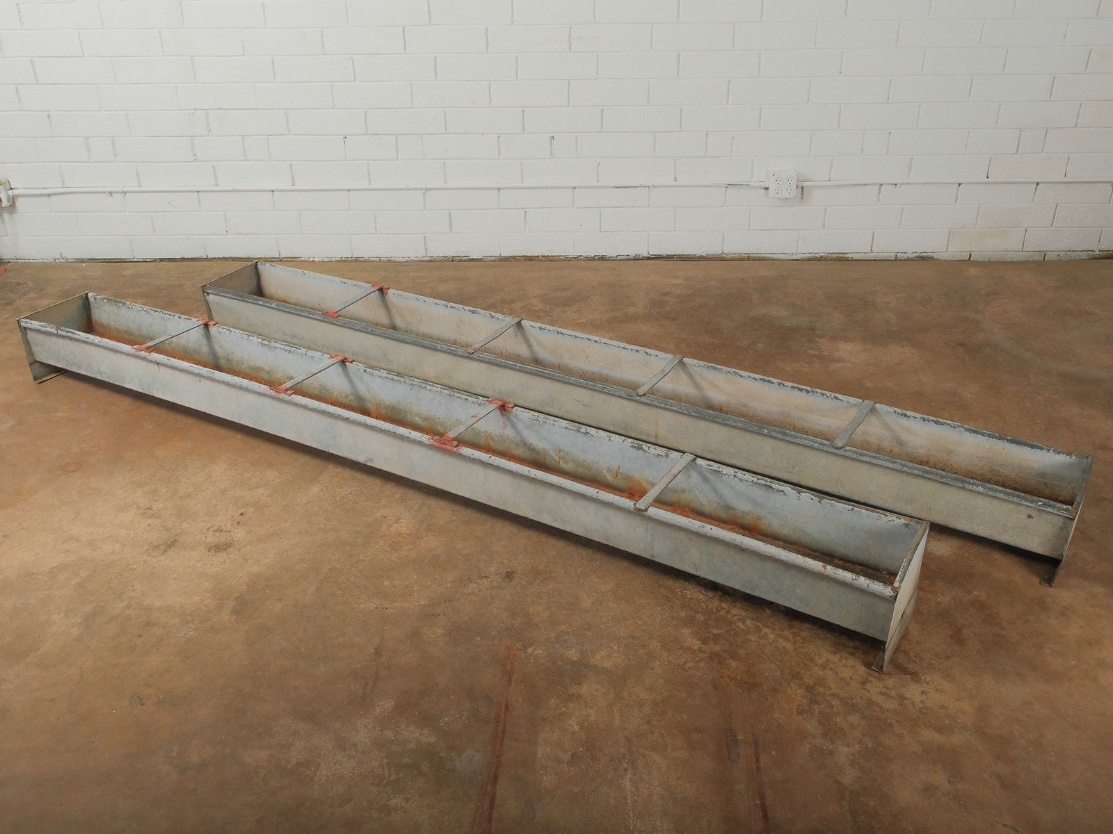 Pair Industrial Galvanized Metal Feed Troughs: Pair of galvanized metal livestock feed troughs with interior divider supports and natural rust patina. Long rectangular form originally used for feeding livestock and well suited today for planters,