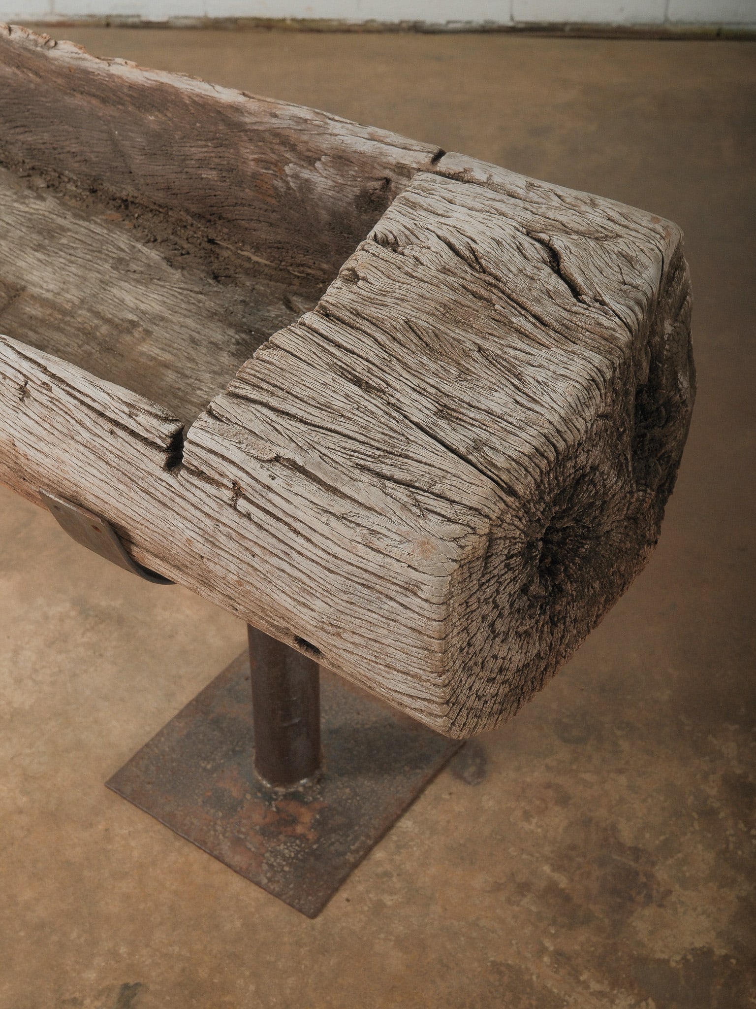 Primitive Wooden Beam Trough on Iron Supports: Large hand-carved wooden trough mounted on a metal stand base. The timber shows natural age, cracks, and weathered character from long use. A striking rustic piece suitable for garden display, planter