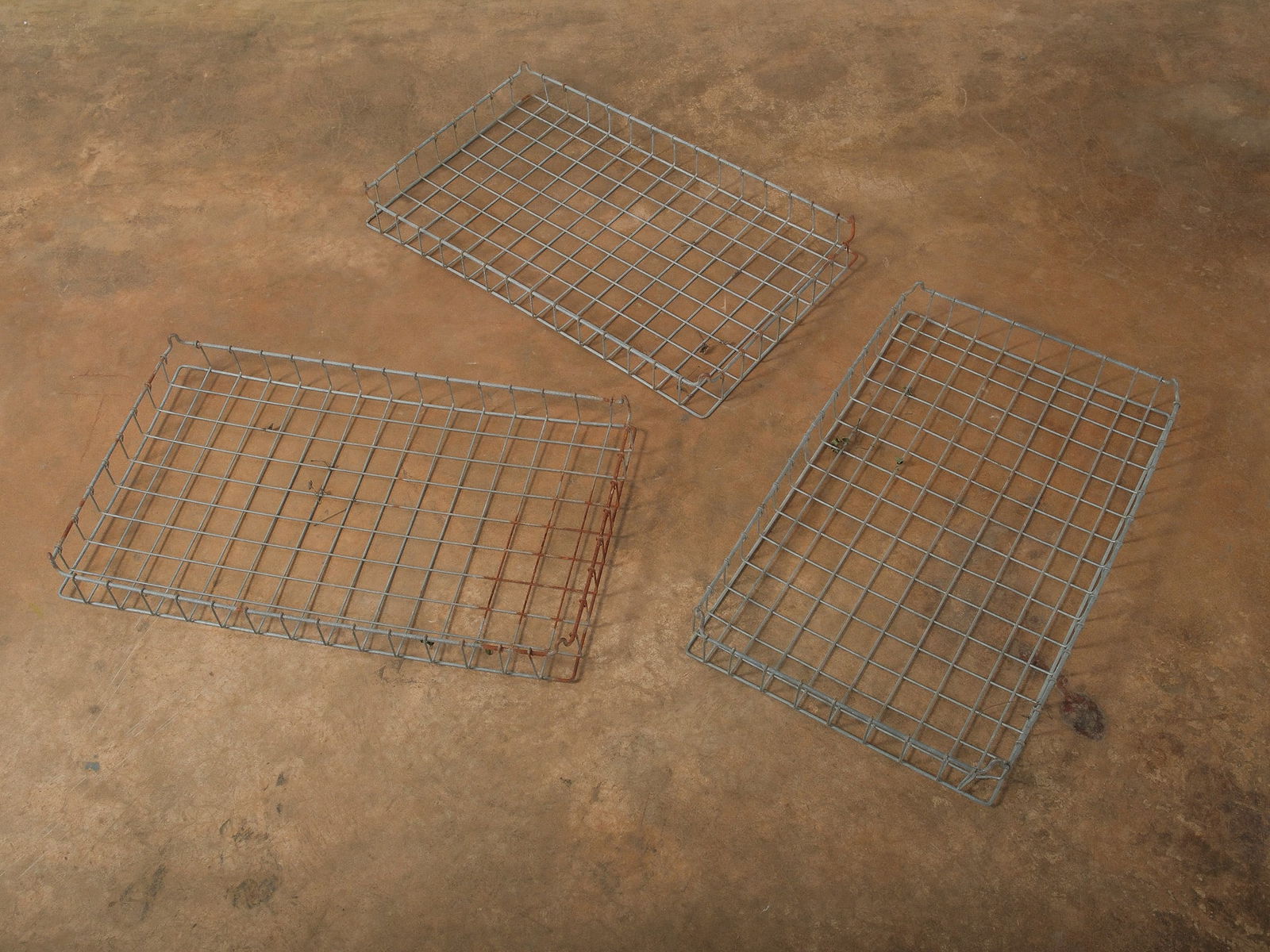 Set of Three Metal Wire Trays: Set of three rectangular metal wire trays featuring grid construction with raised sides and a galvanized finish. The trays show light wear and areas of surface oxidation consistent with age and use. S