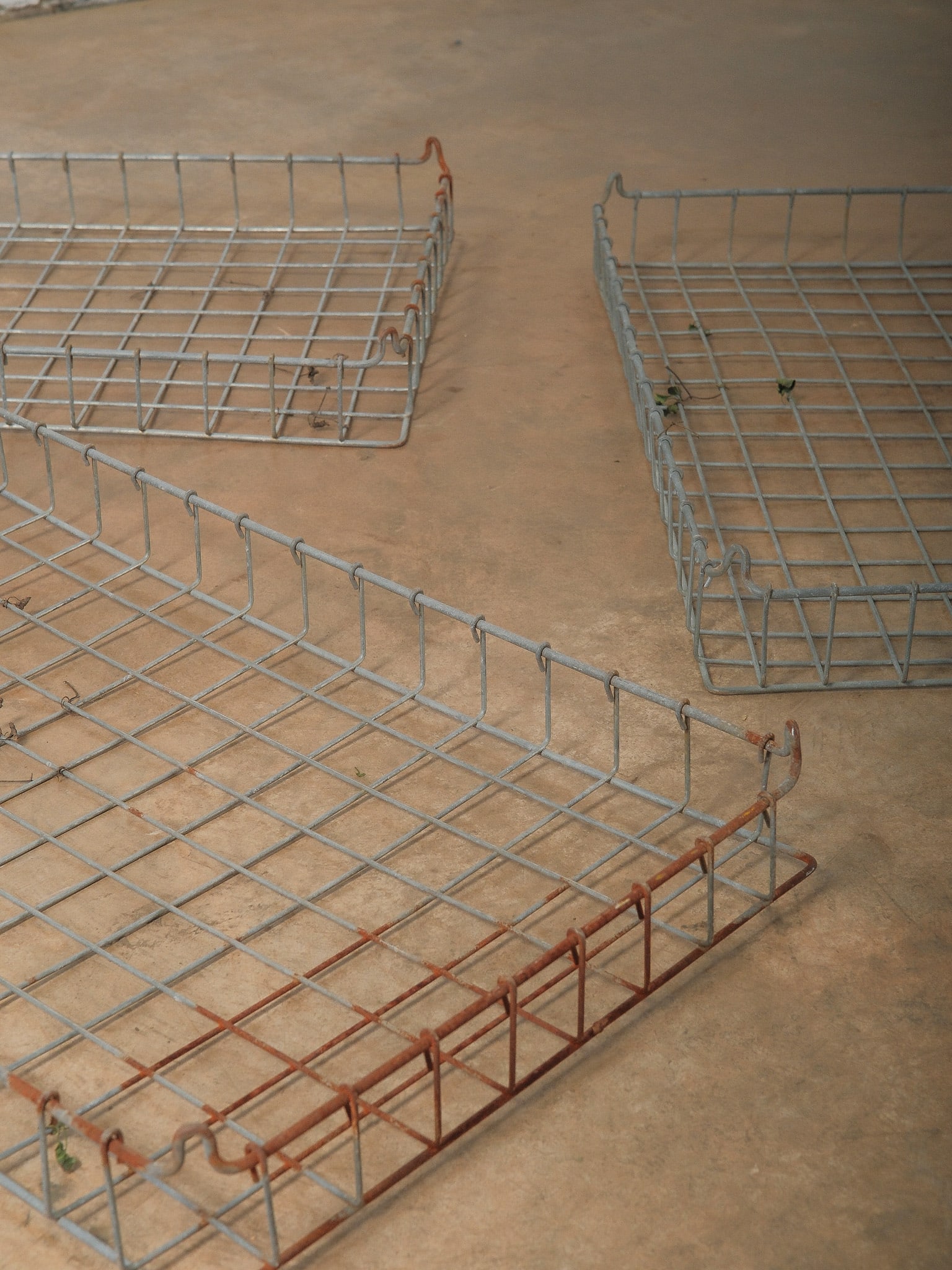 Set of Three Metal Wire Trays: Set of three rectangular metal wire trays featuring grid construction with raised sides and a galvanized finish. The trays show light wear and areas of surface oxidation consistent with age and use. S