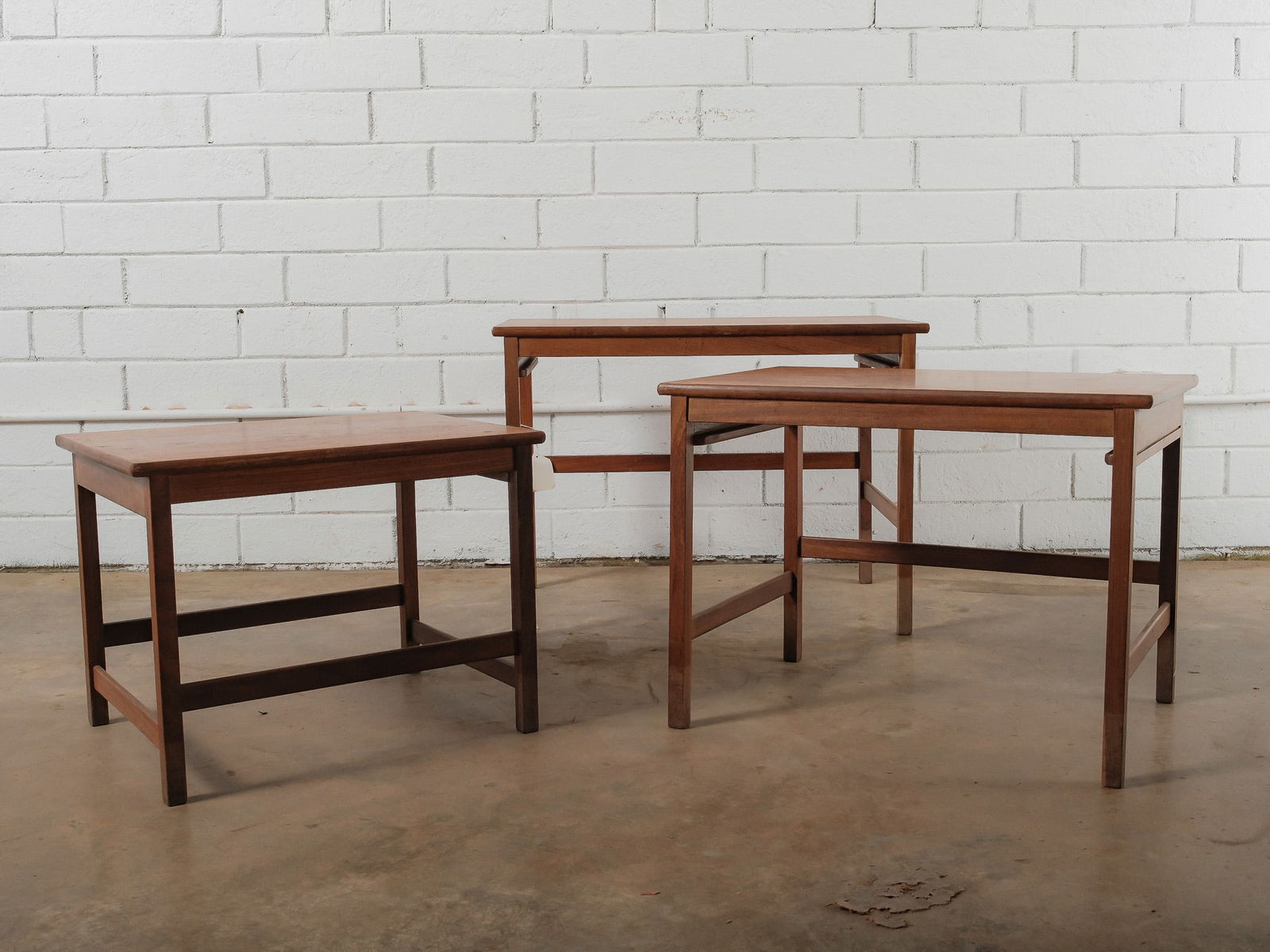 Set of Three MCM Nesting Tables: This mid-century modern set includes three rectangular nesting tables designed to stack neatly together when not in use. Each table features straight legs, clean lines, and a warm wood finish. Practic