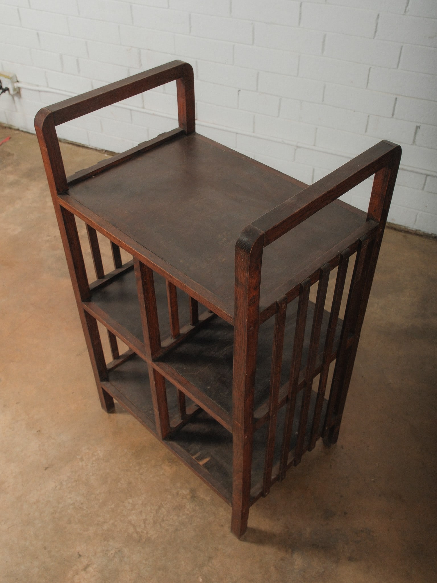 Wooden Three-Tier Shelf Unit: Vintage wooden three-tier shelf unit featuring a sturdy frame with vertical slat sides and open shelving. The piece has a warm wood finish with visible grain and a simple, functional design suitable f