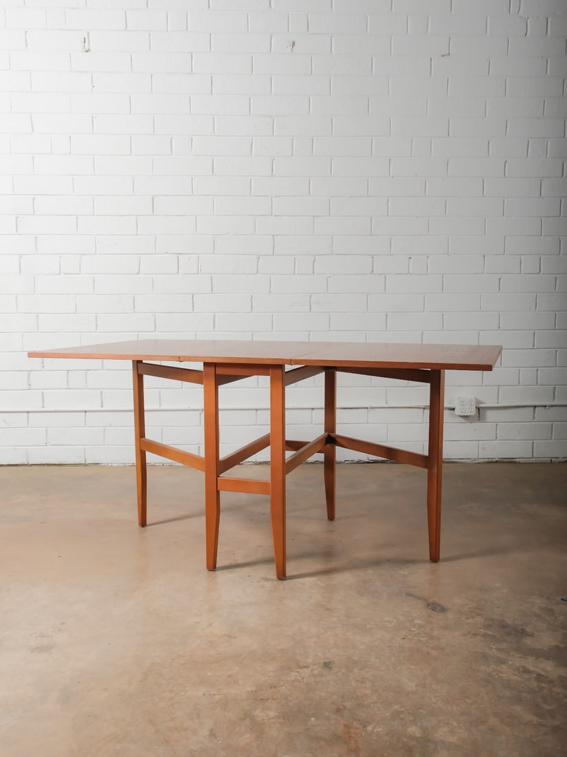 Drop-Leaf Gate Leg Dining Table: Rectangular wood dining table with dual drop leaves and straight legs with stretcher supports. Expands for additional seating. 14.5 " wide in center, each leaf measures 22.5" x 32".