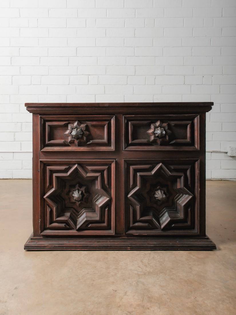 Carved Paneled Cabinet with Star Motifs: This cabinet features richly carved paneled sides and doors, each centered with a dimensional star-form design. The robust construction and layered moldings give the piece a sculptural, almost archite