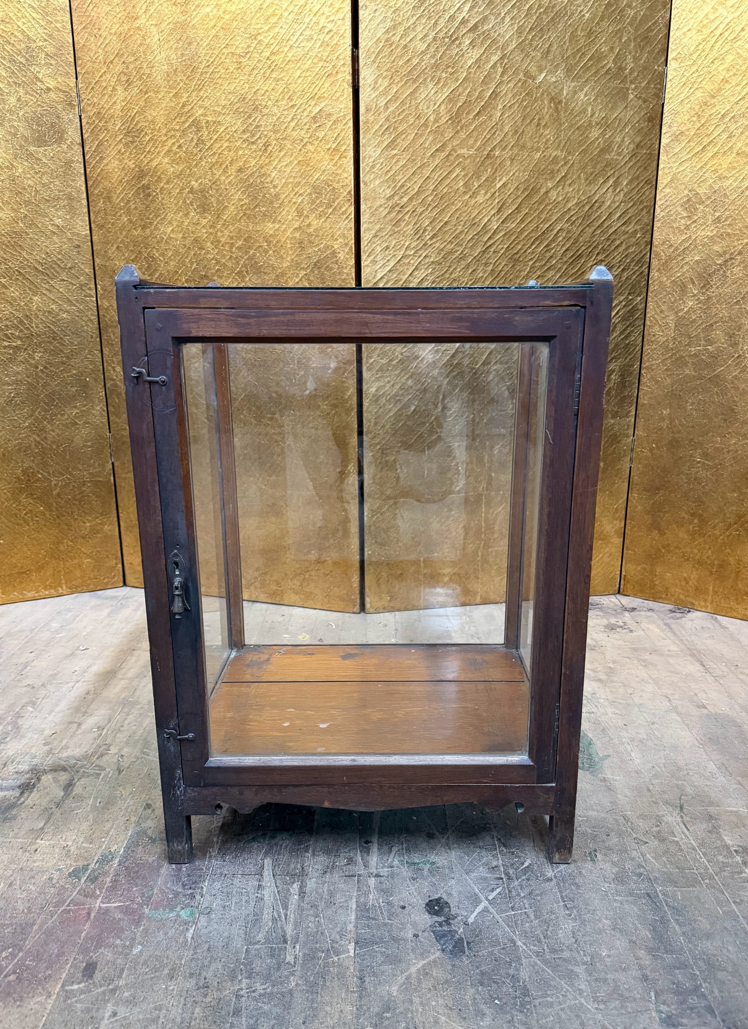 Antique Wooden Countertop Display Cabinet: Antique wooden countertop display cabinet featuring glass panels on all sides and a single hinged glass door with original latch hardware. The simple rectangular form and warm aged wood finish highlig
