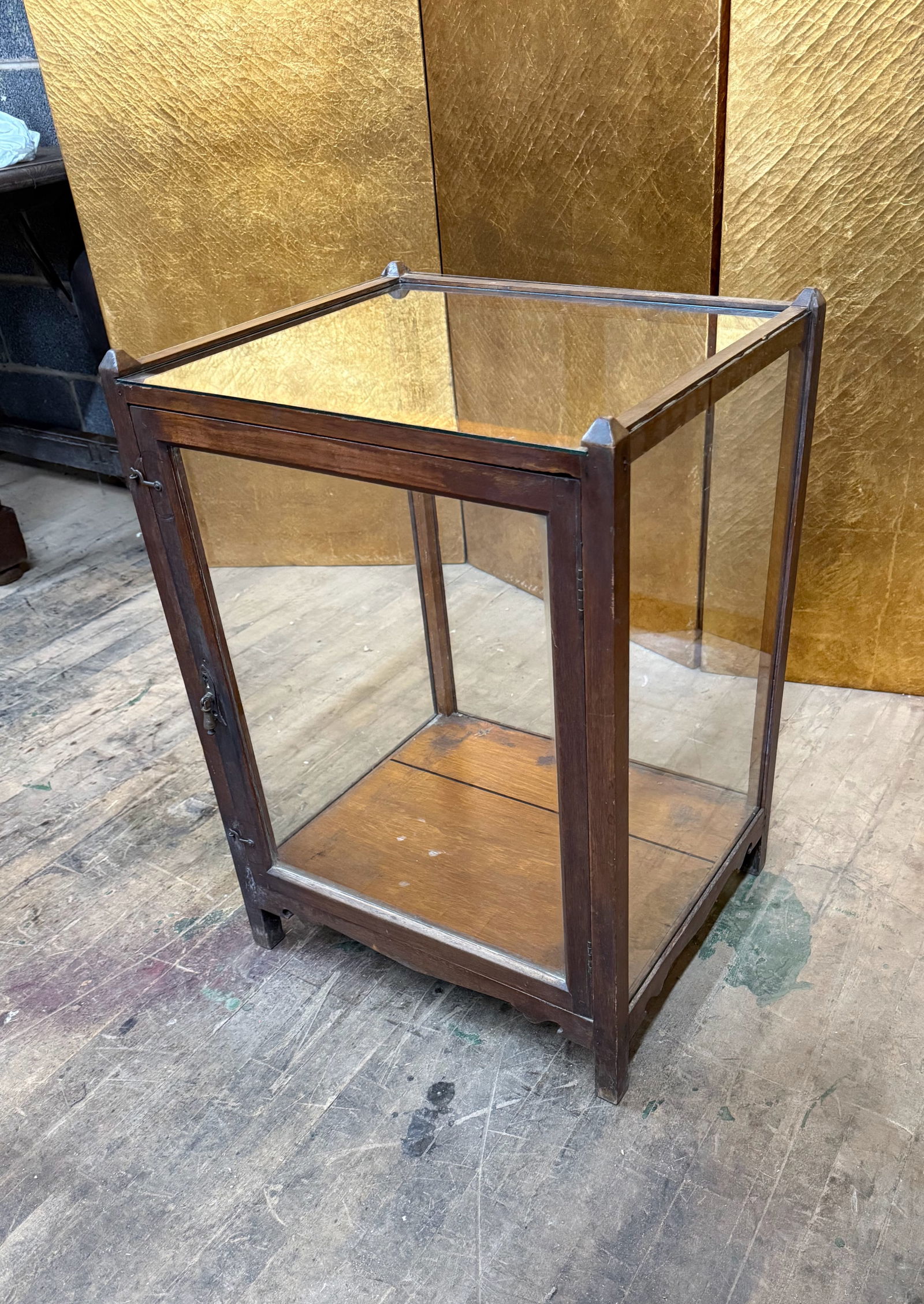 Antique Wooden Countertop Display Cabinet: Antique wooden countertop display cabinet featuring glass panels on all sides and a single hinged glass door with original latch hardware. The simple rectangular form and warm aged wood finish highlig