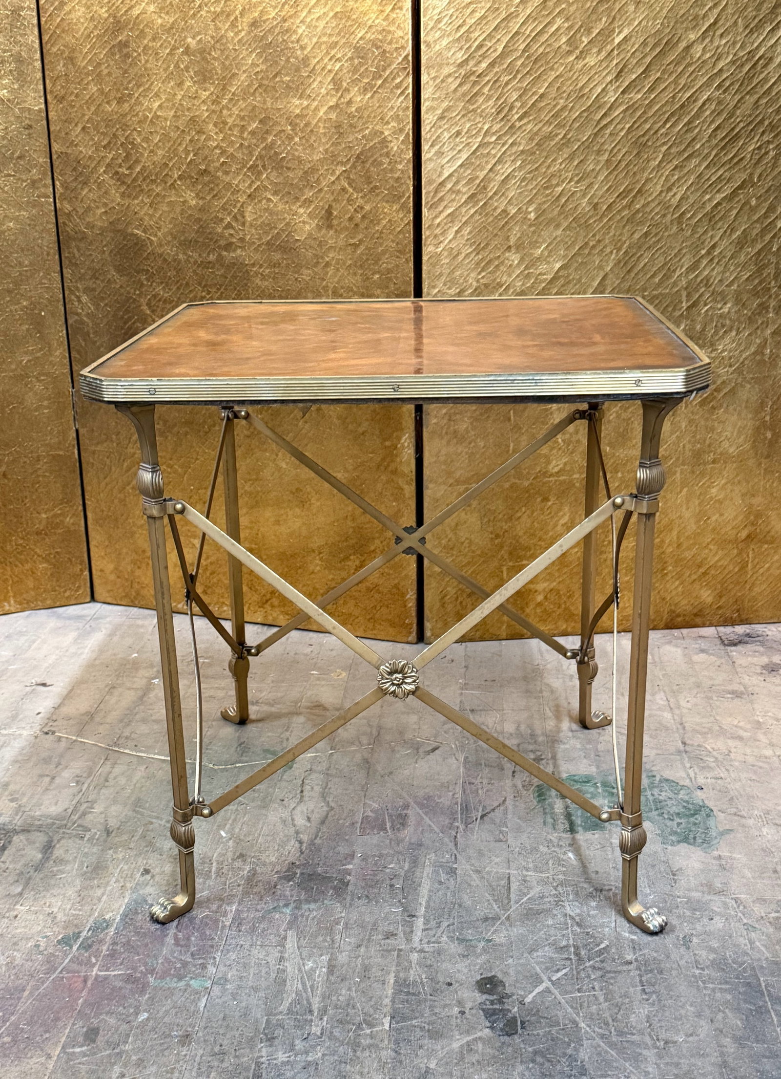 Burl Wood and Brass Regency Style Accent Table: Elegant accent table featuring a square burl wood top set within a brass frame. The table stands on slender brass legs with decorative detailing and claw-style feet, joined by an X-form stretchers wit