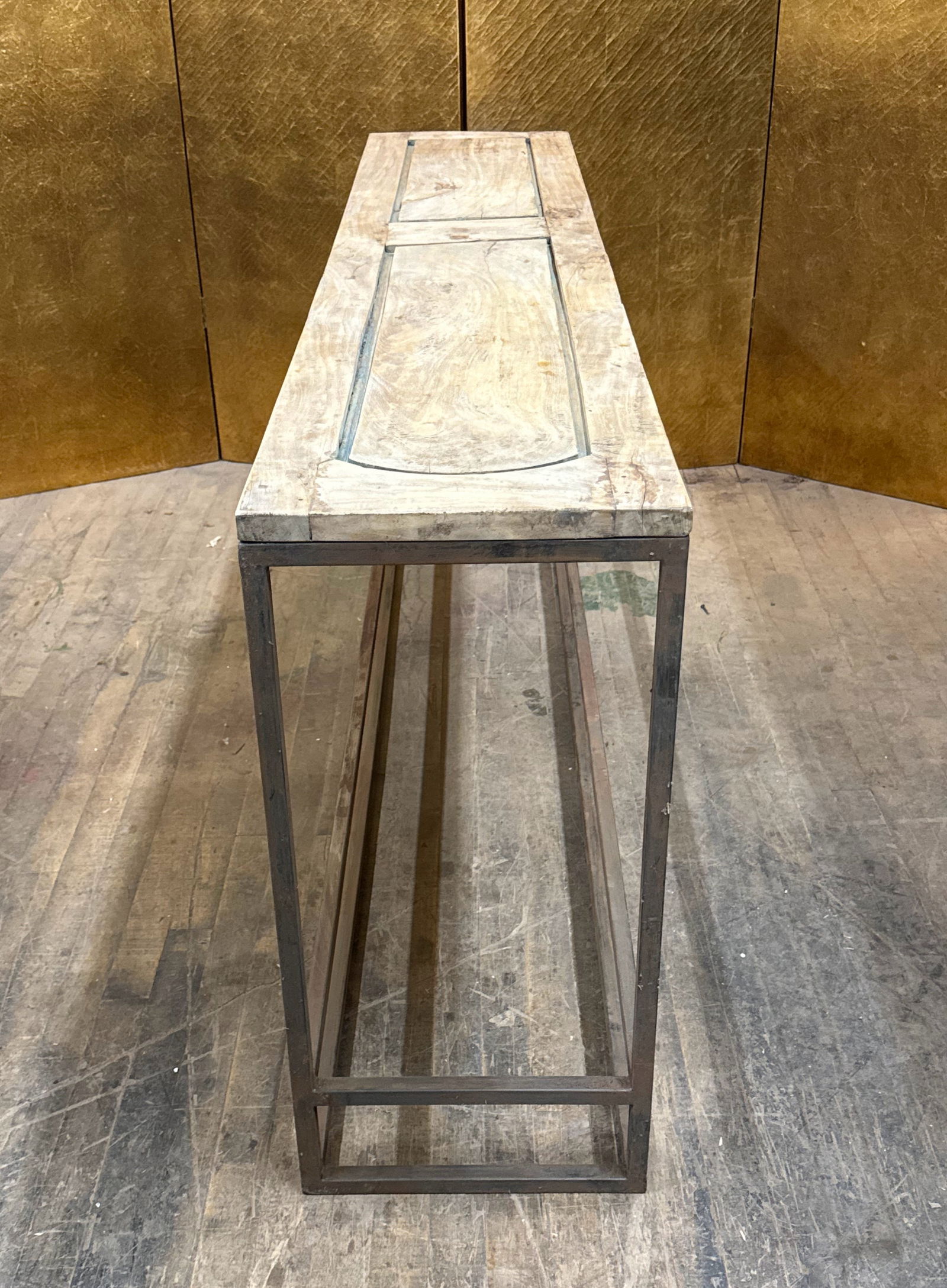 Reclaimed Wood Console Table: Console table made from a reclaimed paneled wood door section with three inset panels and a weathered painted finish highlighting its aged character. The top sits on a sleek iron frame base, creating