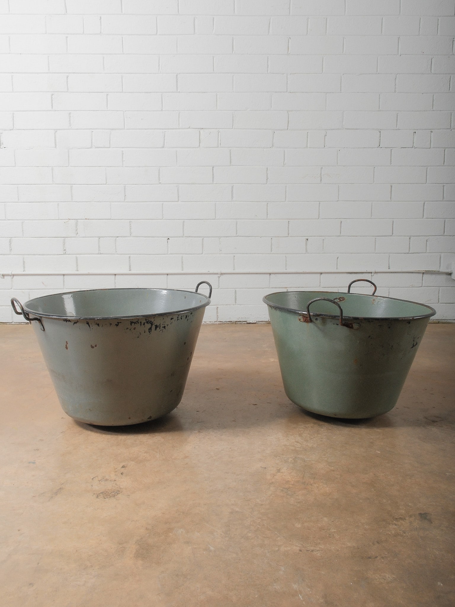 Pair of Large Vintage Enamel Utility Tubs: Matching large enamel-coated metal tubs with side handles. Industrial farmhouse form in muted green tones with interior enamel finish. Perfect for ice bins at your next cookout, wood storage next to y