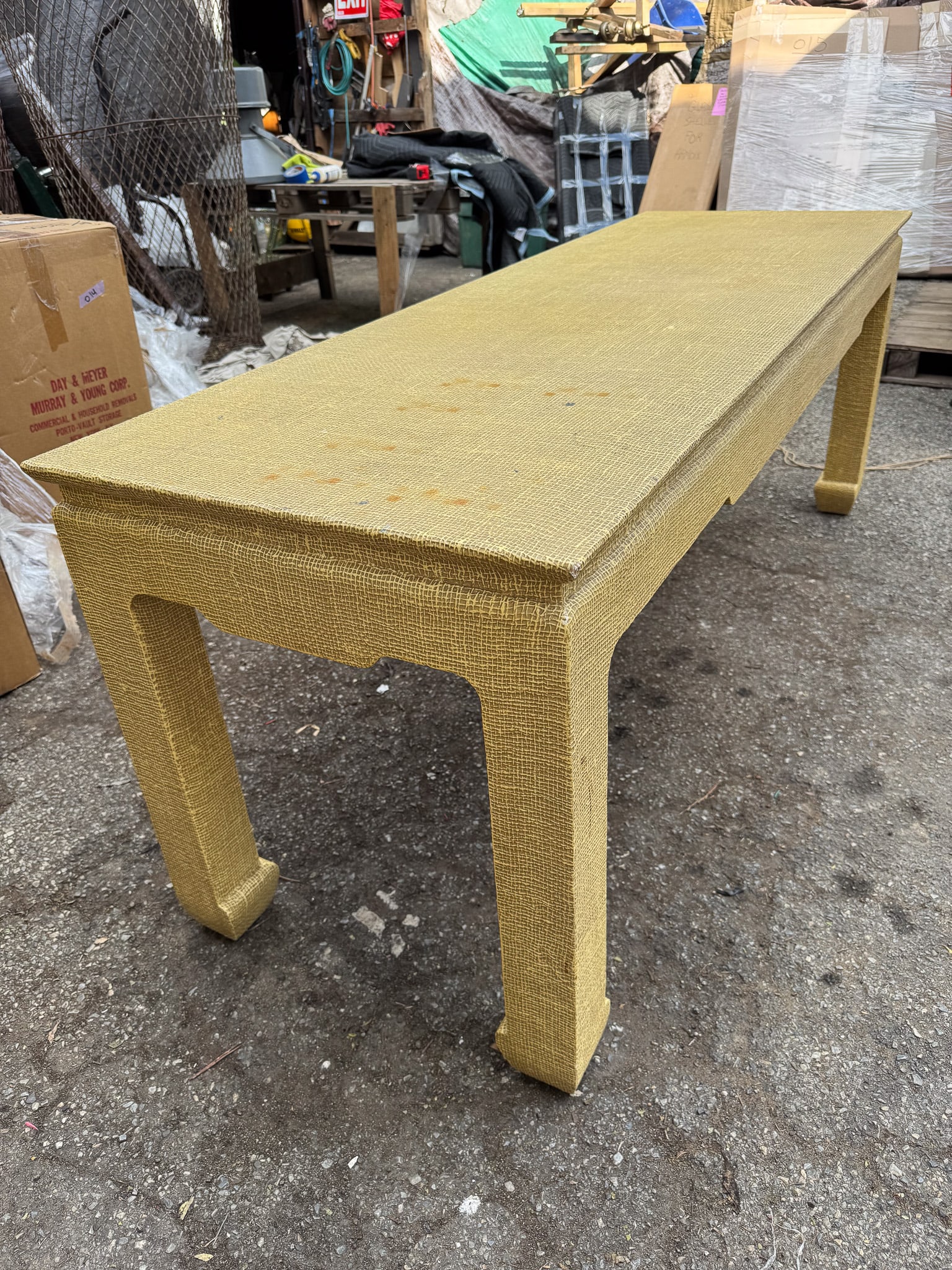 Grass cloth Chinoiserie Table: Rectangular coffee/console table featuring a fully wrapped grass cloth exterior in a warm golden tone, showcasing rich texture and organic depth. The form is distinctly chinoiserie-inspired, with gent