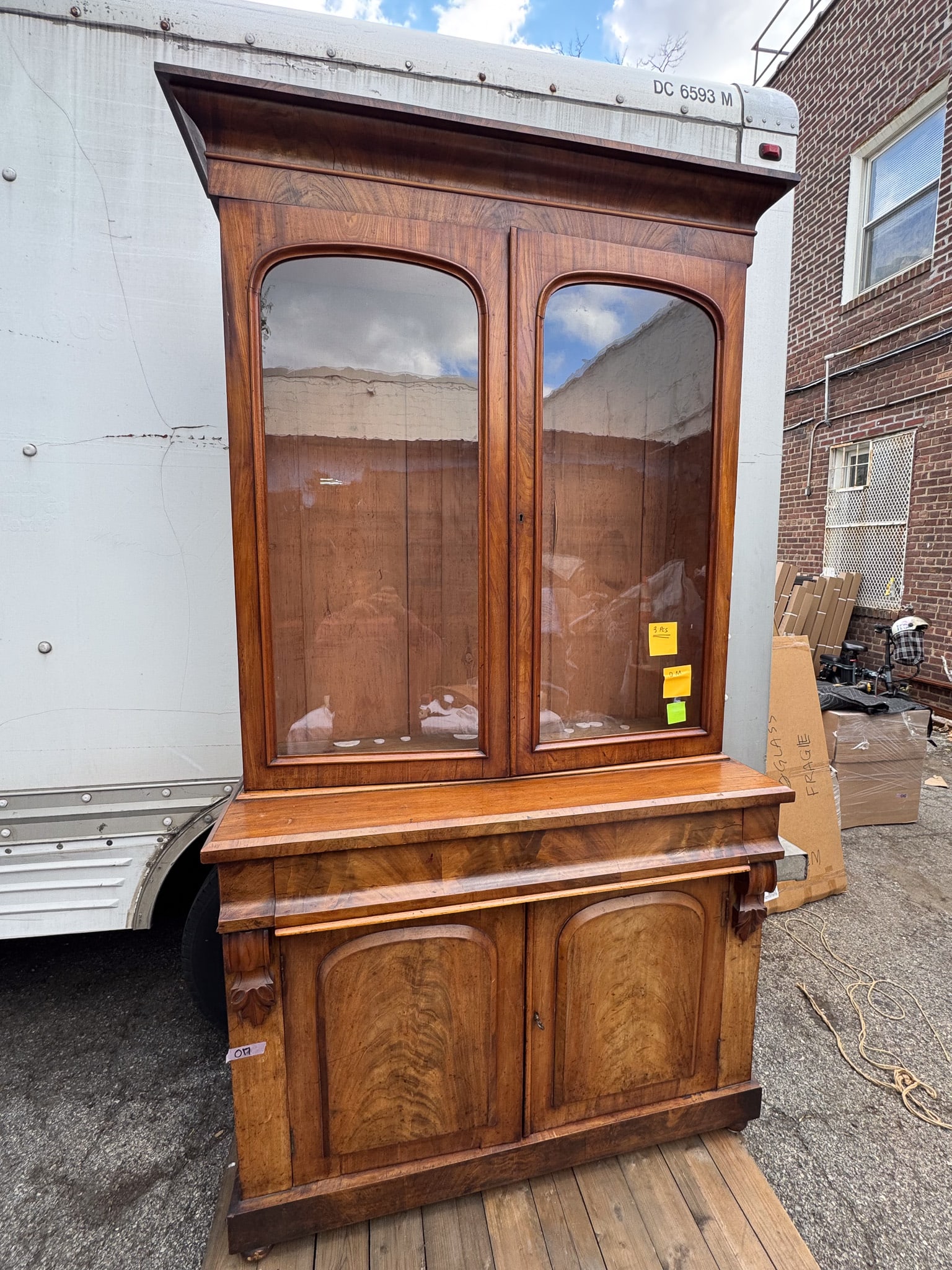 China Cab: Elegant two-part China cabinet or display hutch crafted in richly figured walnut veneer. The upper case features two large glazed doors with softly arched frames, opening to a spacious display interio