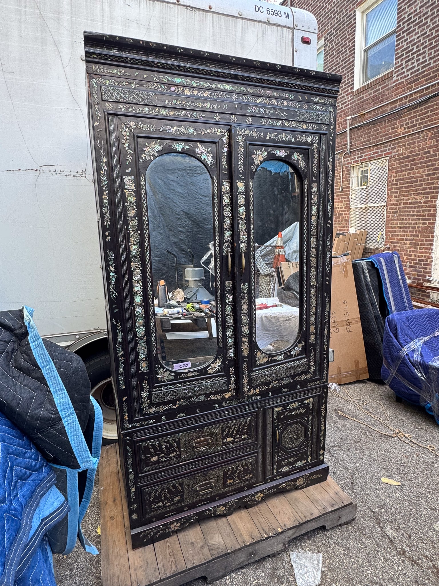 Black Lacquer & Mother-of-Pearl Inlaid Cabinet: Highly decorative black lacquer cabinet intricately inlaid with mother-of-pearl depicting floral and foliate motifs throughout. Upper double doors feature inset mirrors and open to interior storage, w