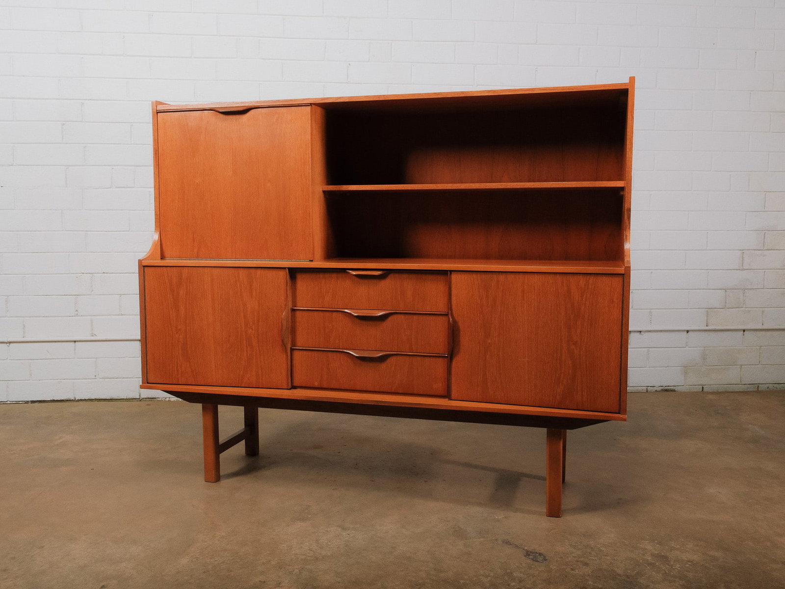 MCM Hutch: Mid-century modern hutch cabinet comprised of an upper shelving unit with an enclosed cabinet and an expansive open display shelf over a lower cabinet featuring three drawers and two sliding-door