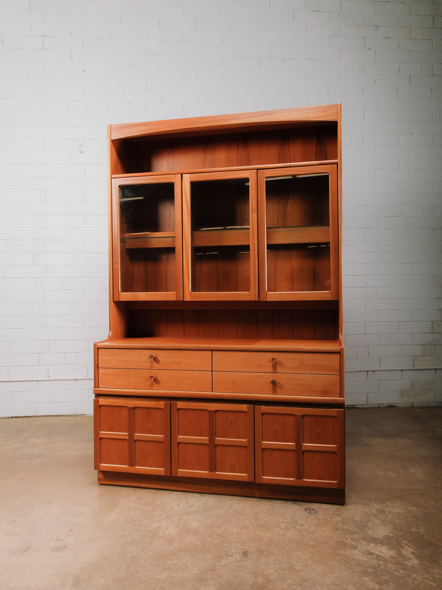 MCM Credenza: Mid-century modern display cabinet featuring an upper open display shelf over three illuminated glass-front display cabinets with glass shelving, ideal for showcasing fine china, crystal, art glass, o