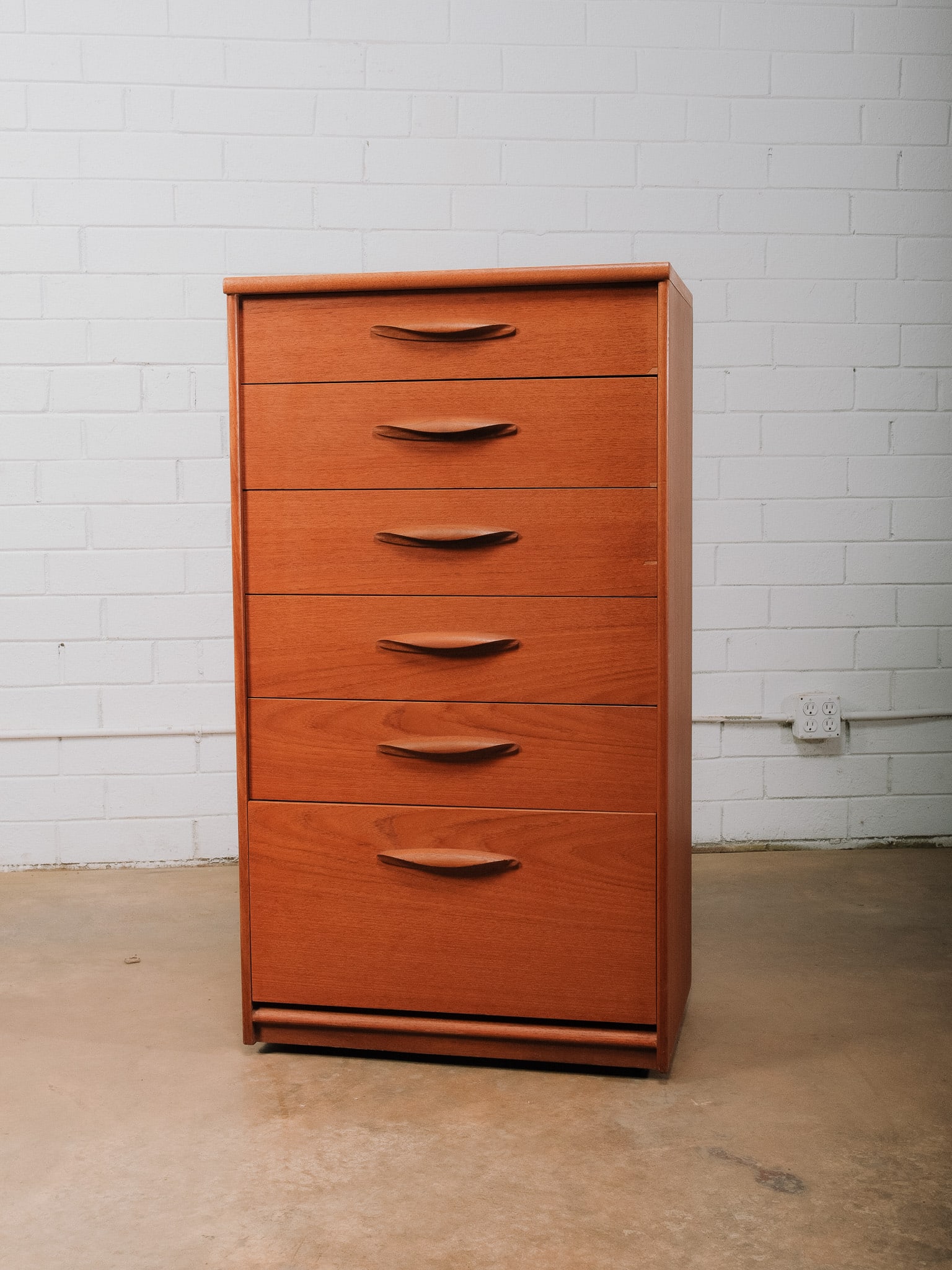 MCM Bachelor Chest: Mid-century modern tall chest featuring six drawers. The clean, streamlined case highlights beautiful wood grain and minimalist Scandinavian-inspired styling. A timeless storage piece well suited for