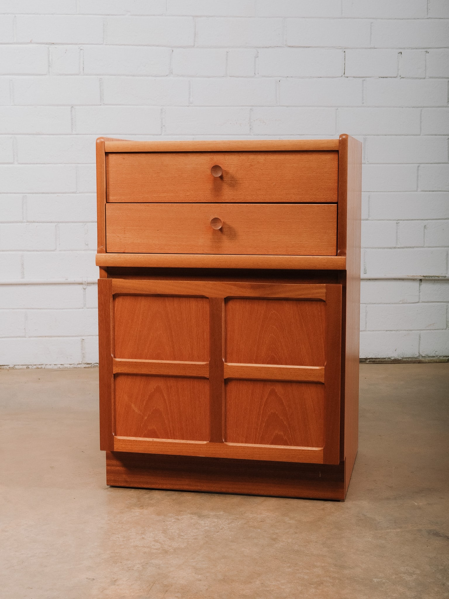 MCM Cabinet with Two Drawers: Mid-century modern cabinet featuring two upper drawers above a pair of paneled cabinet doors, offering a practical combination of concealed storage. The clean architectural form is accented by