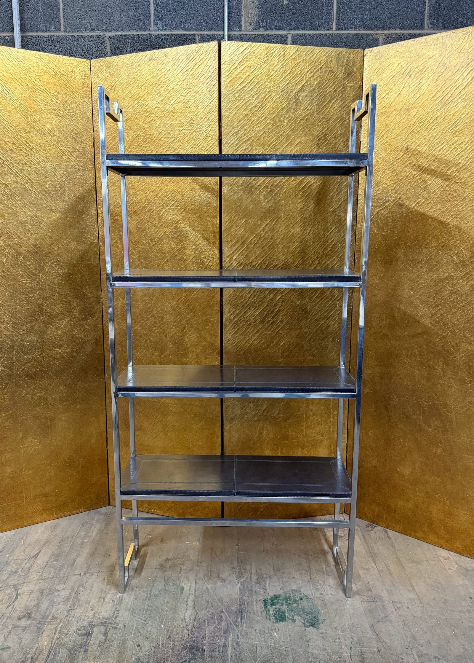 Modern Chrome and Black Leather Four-Tier Shelving Unit: Contemporary shelving unit featuring a polished chrome metal frame with four tiers of black leather shelves. The clean architectural frame and contrasting materials create a sleek modern aesthetic.
