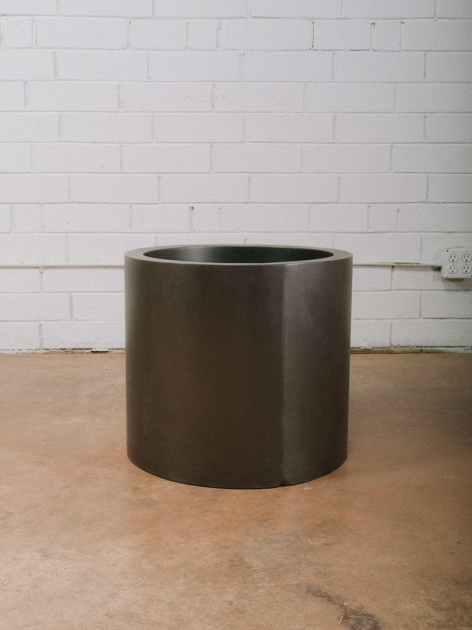 Modern Metal Drum Accent Table with Glass Inset Top: Modern drum-style accent table featuring a sculptural black metal cylindrical base with a recessed tempered glass inset top. Its clean geometric form and minimalist aesthetic make it an ideal side
