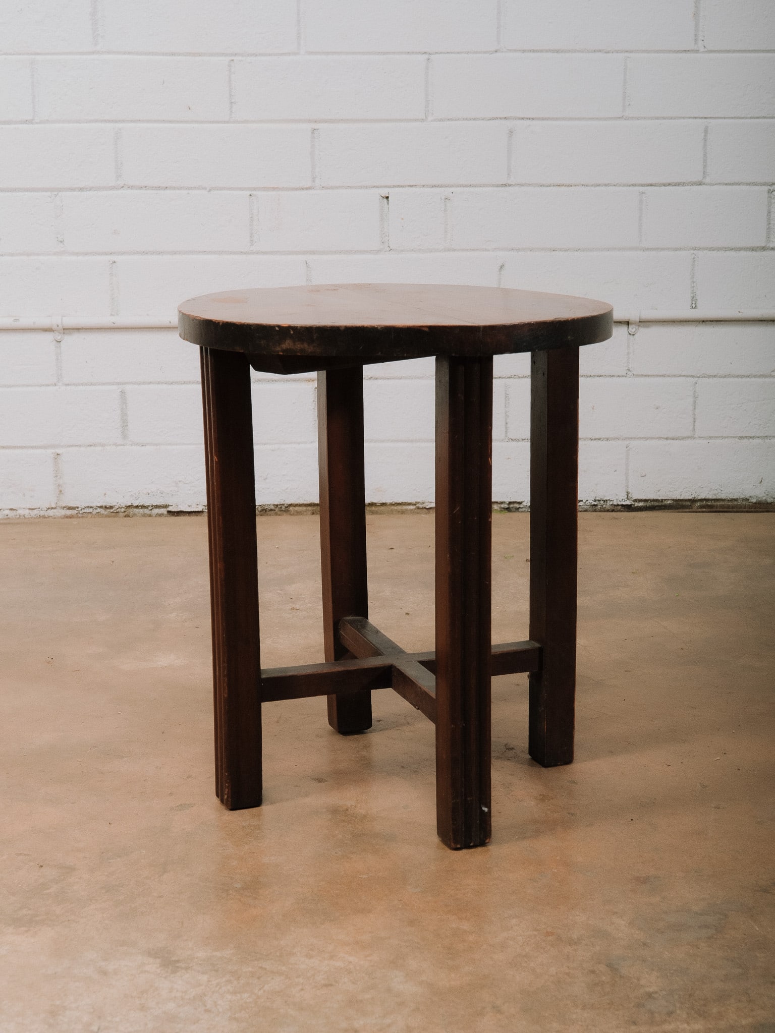 Small Round Wood Accent Table: Small round wood accent table featuring a circular top with parquet-style wood veneer and a sturdy four-leg base connected by stretchers. Its compact size makes it ideal as a side table, lamp table,