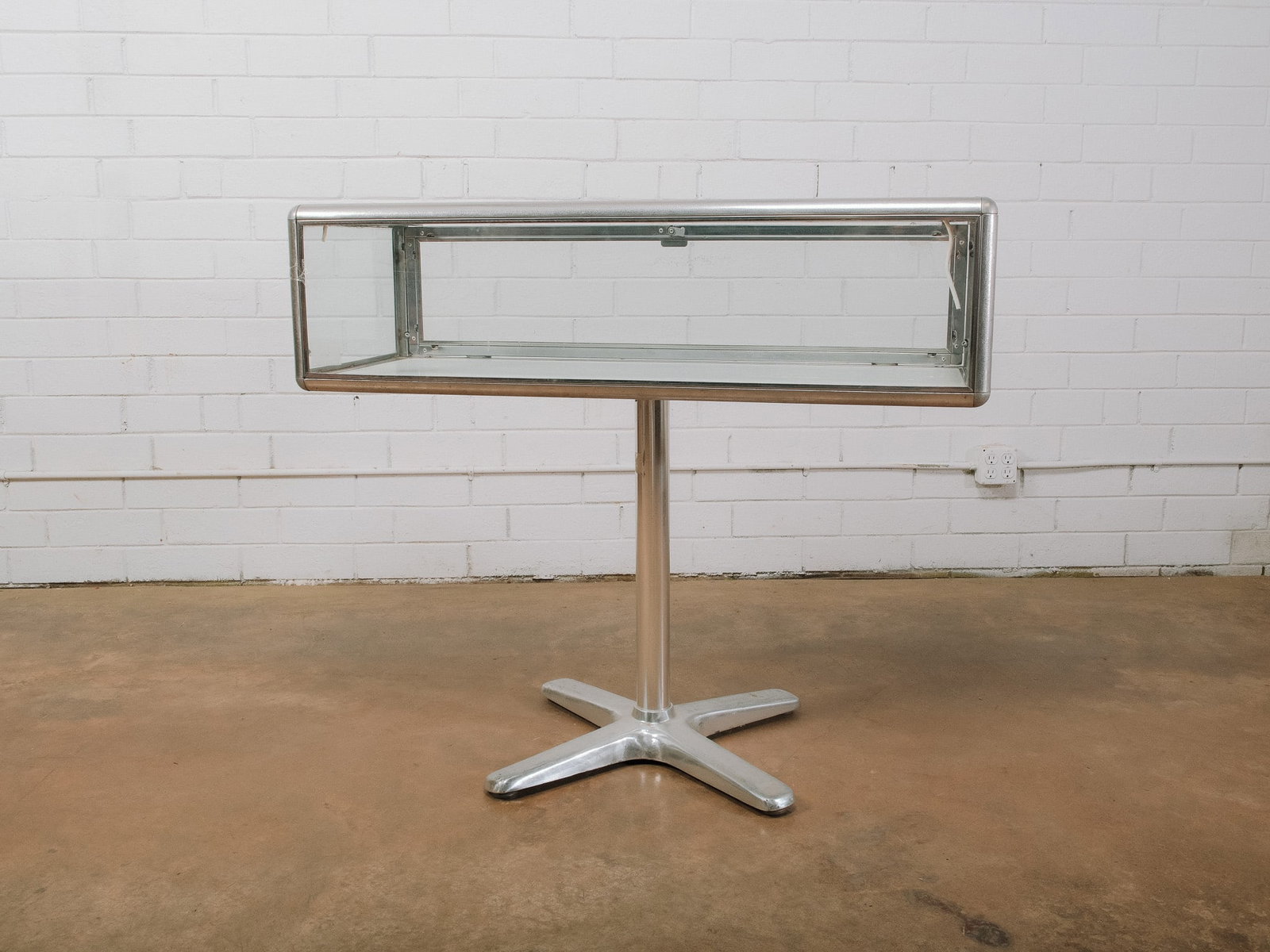 Aluminum & Glass Display Showcase Pedestal: Freestanding aluminum and glass display showcase with a sleek pedestal base and four-star foot. The locking glass display case provides 360-degree visibility, making it ideal for showcasing